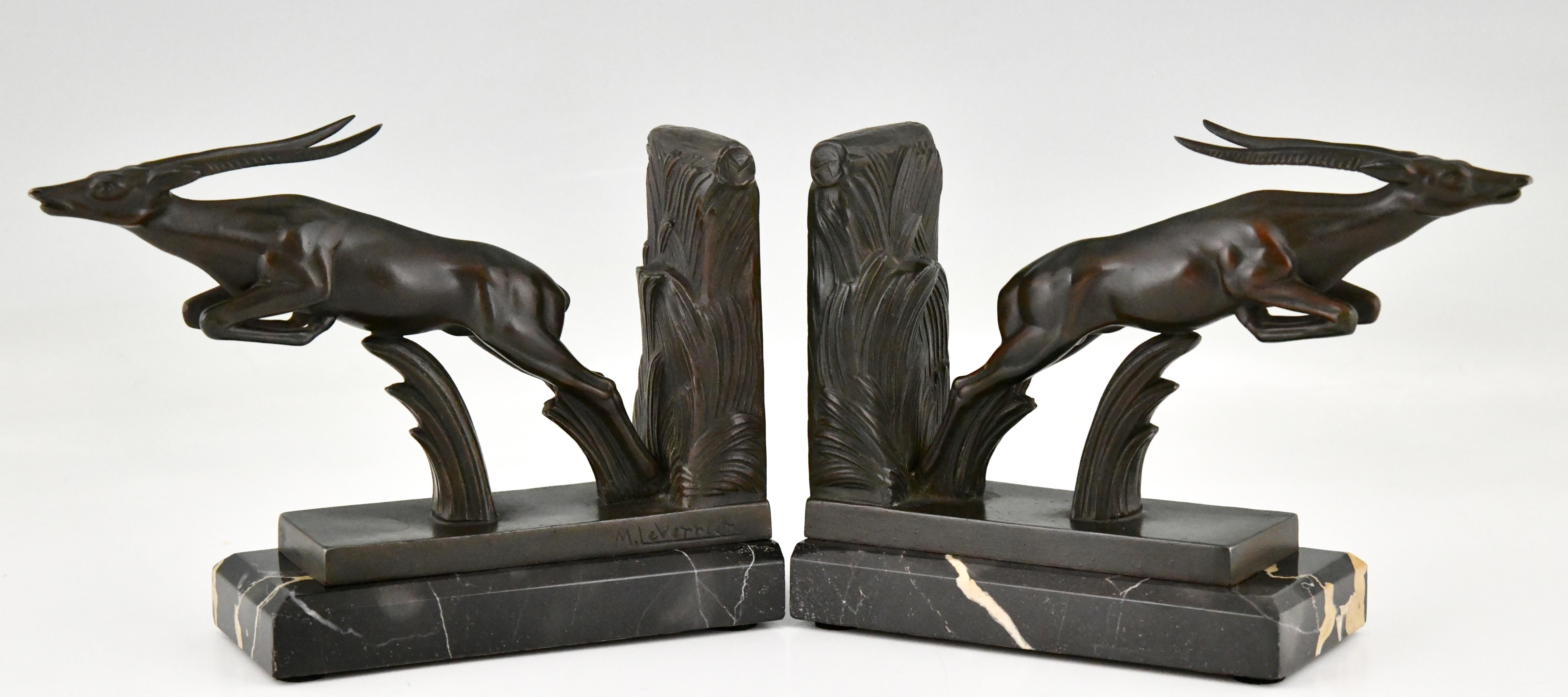 Serre-livres Art Déco en forme de cerf bondissant par Max Le Verrier. 
Les sculptures sont exécutées en métal patiné et montées sur des socles en marbre Portor. 
France 1930.