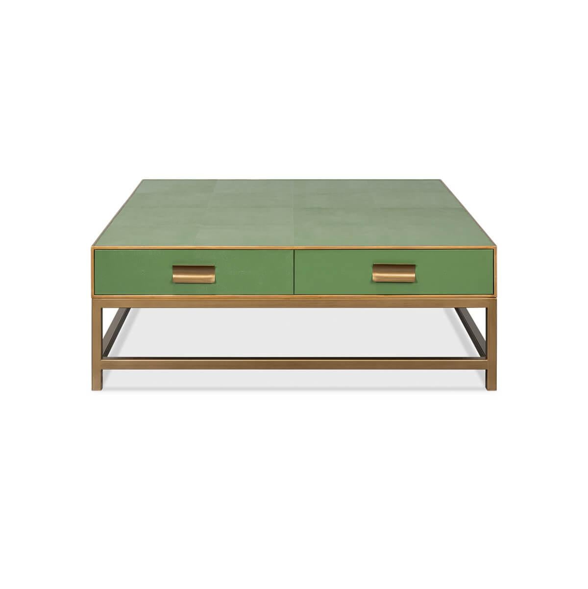 Crafted from wood with a shagreen embossed leather wrapped top, this square coffee table is finished with gold trim and hardware. With two drawers and raised on cube-form base with stretchers. The low-profile design makes it ideal for a functional