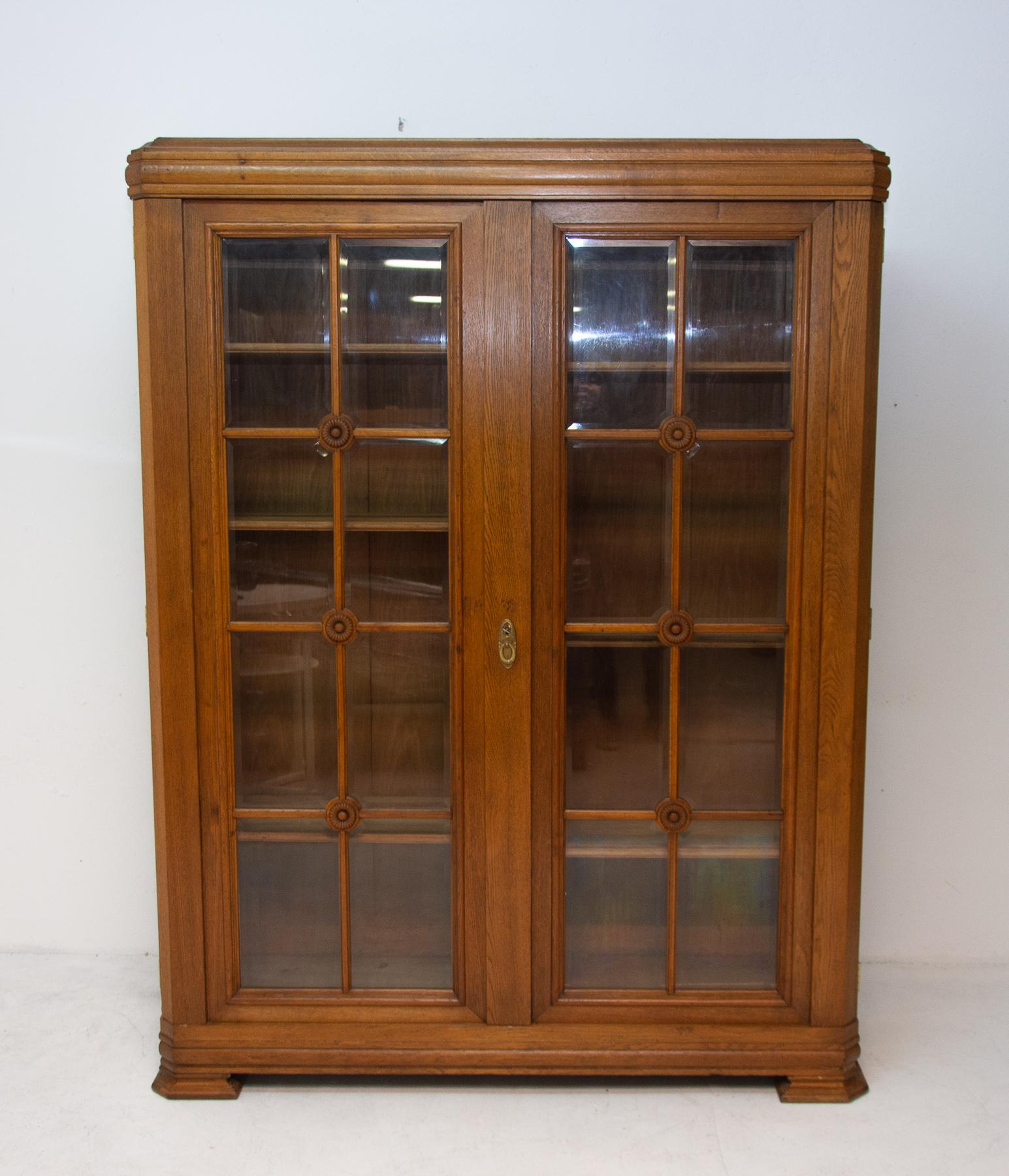 Art Deco library cabinet, made in the 1930s in Bohemia. It features a regular shapes, a solid structure, and four massive legs on which the library stands. It´s made of oakwood.
The cabinet is generally in good vintage condition with slight signs
