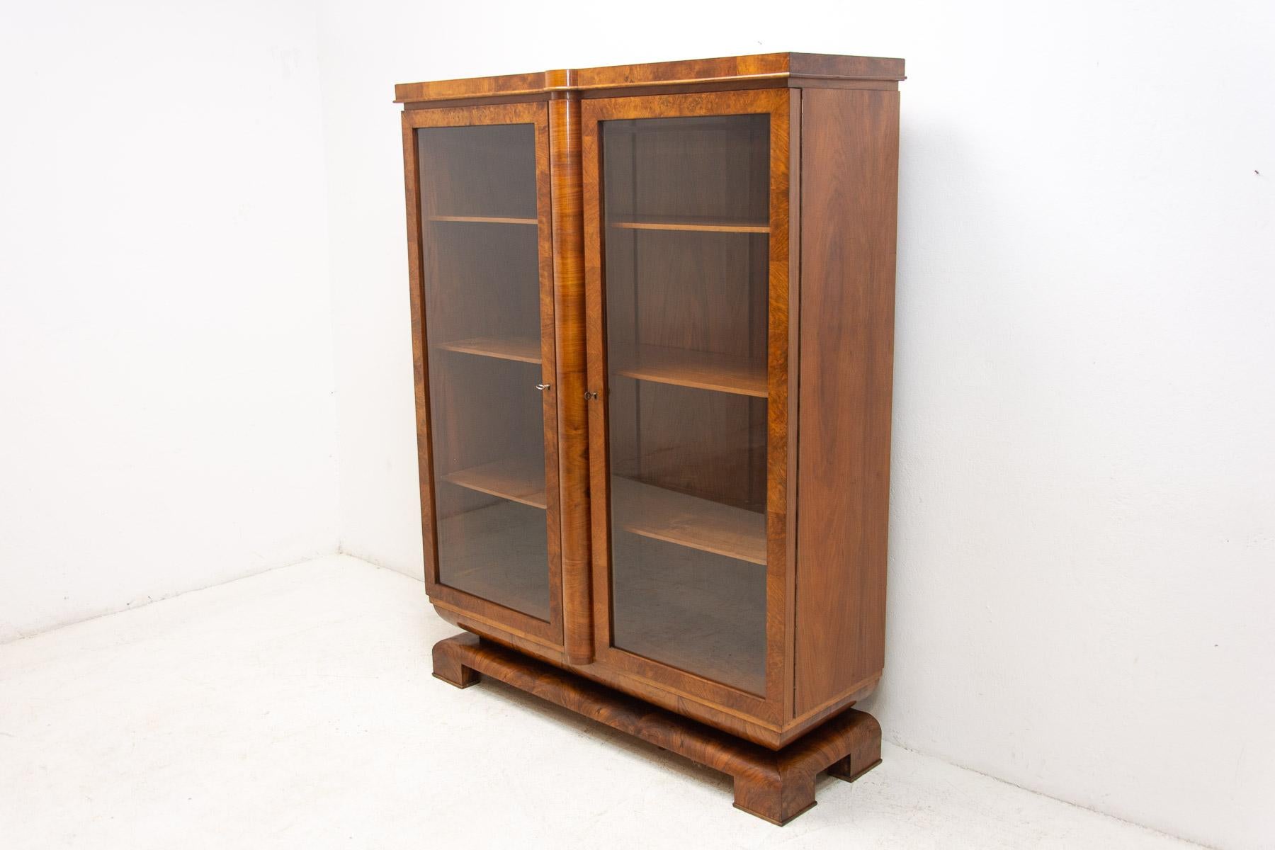 Art Deco Library cabinet, made in the 1930s in Bohemia. It features a regular shapes, a solid structure, and a geometric base on which the library stands. It´s made of walnut wood.
In very good Vintage condition, showing slight signs of age and