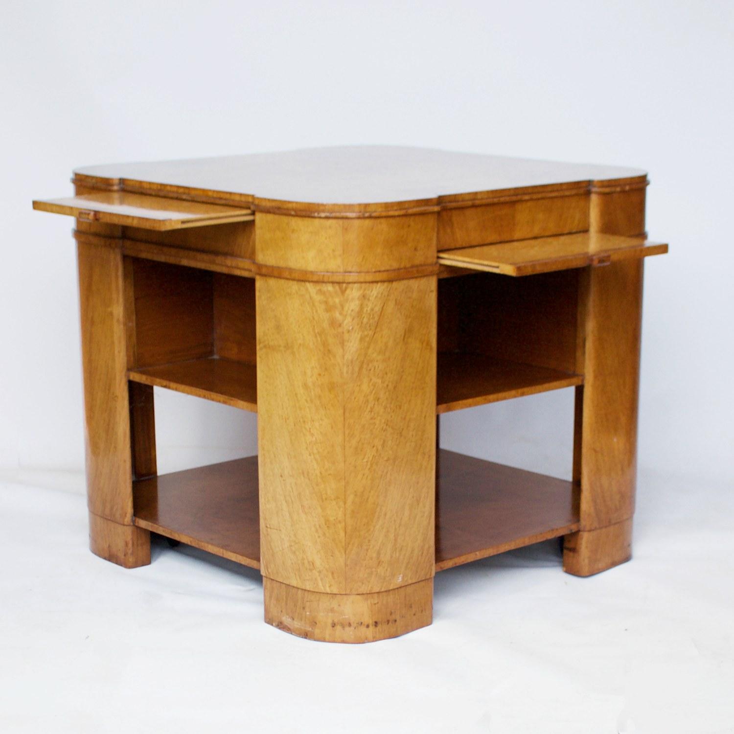 An Art Deco library table. Burr walnut veneered throughout with four pullout / pull-out bird's-eye maple veneered shelves. 

Dimensions: H 62cm, W/D 69cm 

Origin: English

Date: circa 1930

Item number: 801211

All of our furniture is