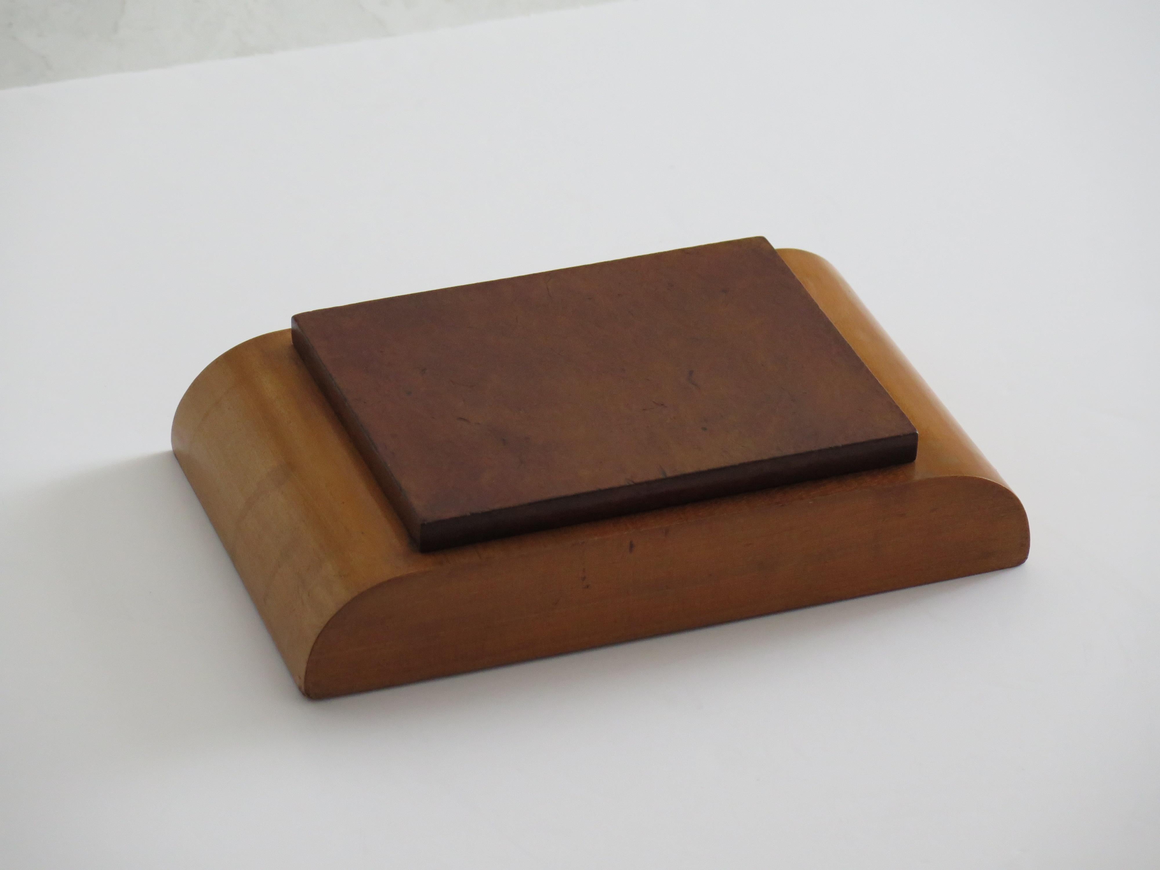 Caja inglesa de época Art Decó de muy buena calidad, con tapa de dos maderas contrastadas, tapa abatible y un compartimento interior, fechada hacia 1925.

La caja tiene líneas Art Déco muy de la época,  con forma rectangular baja y lados geométricos
