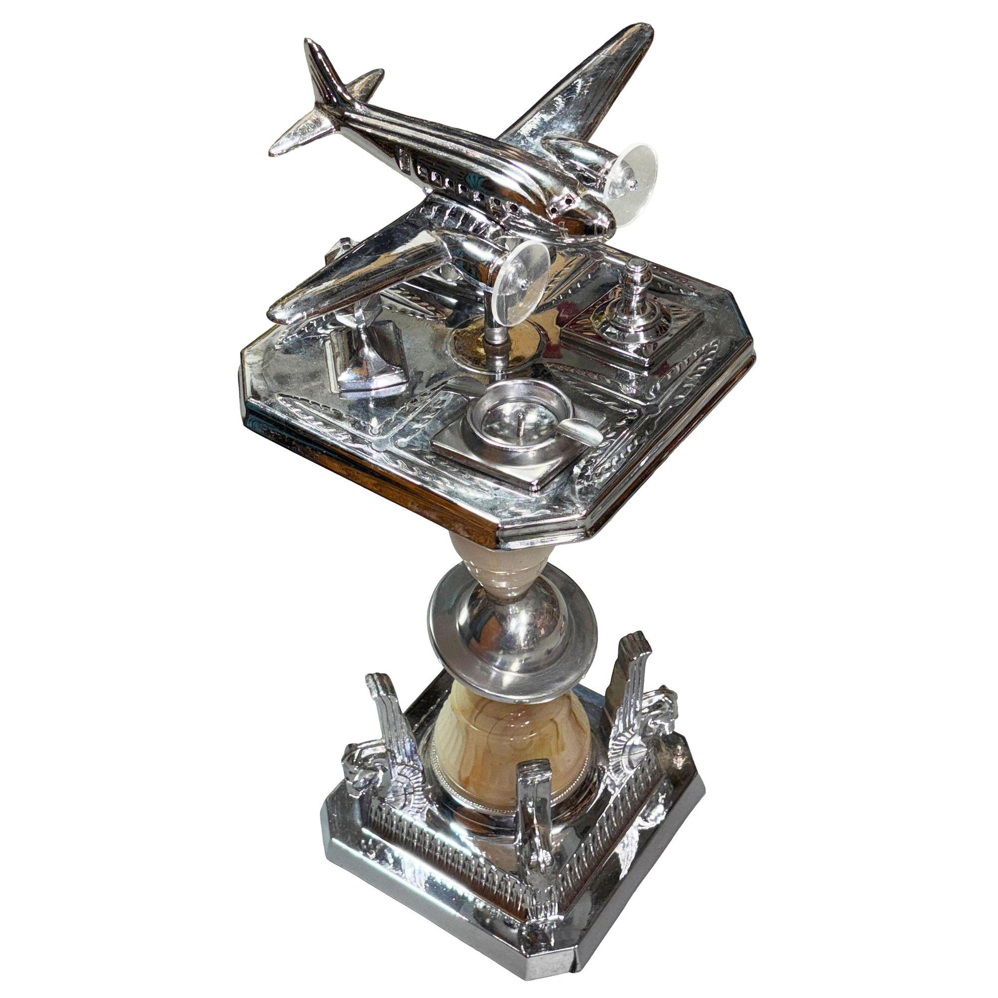 Art-Déco-Chromständer mit einem beleuchteten Flugzeug in der Mitte, das der legendären Douglas DC-3 nachempfunden ist, und einem zusätzlichen beleuchteten Sockel aus Kunstglas. Diese Akzentlampe und dieser Aschenbecher mit doppeltem Verwendungszweck