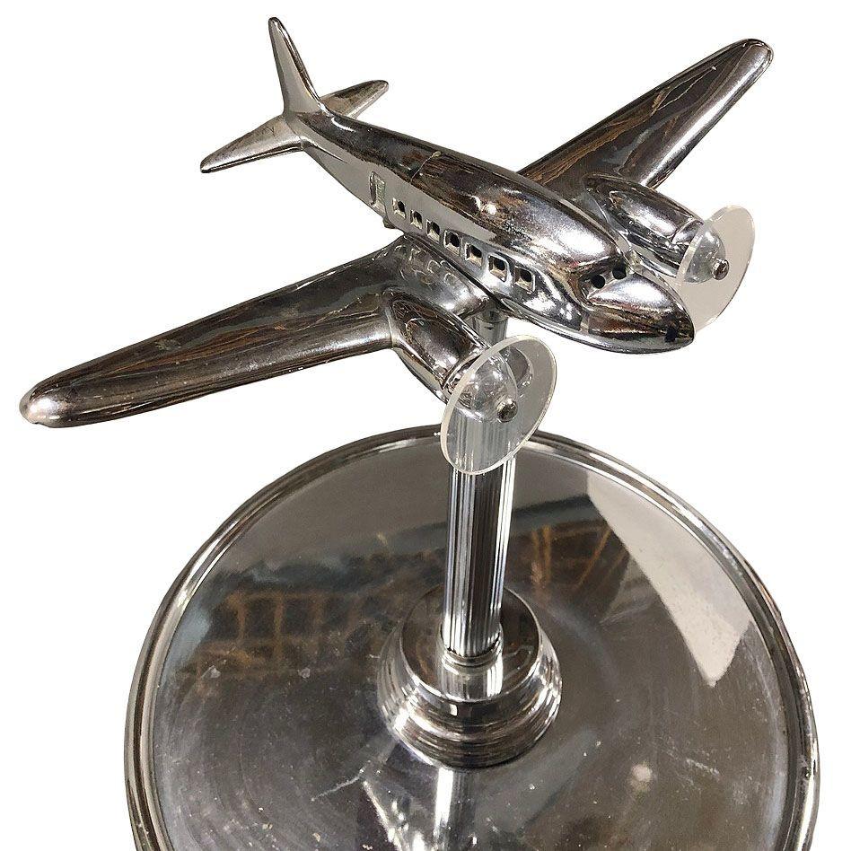 Art Deco chrome side table featuring a light-up airplane in the center, fashioned after the iconic Douglas DC-3, with an additional light-up art glass base. This dual-purpose accent lamp and side table piece boasts a streamlined design, blending