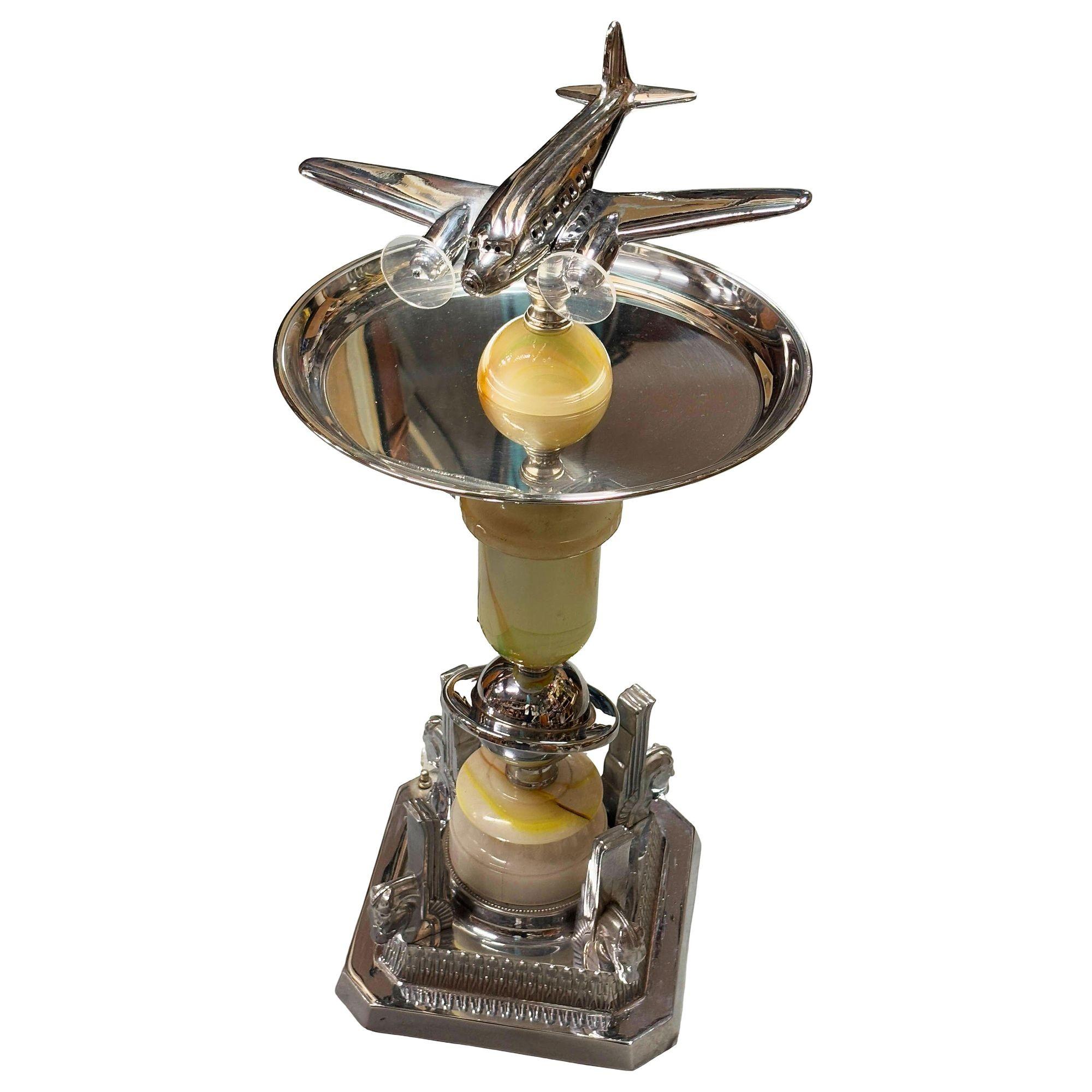 Art Deco chrome side table featuring a light-up airplane in the center, fashioned after the iconic Douglas DC-3, with an additional light-up art glass base. This dual-purpose accent lamp and side table piece boasts a streamlined design, blending