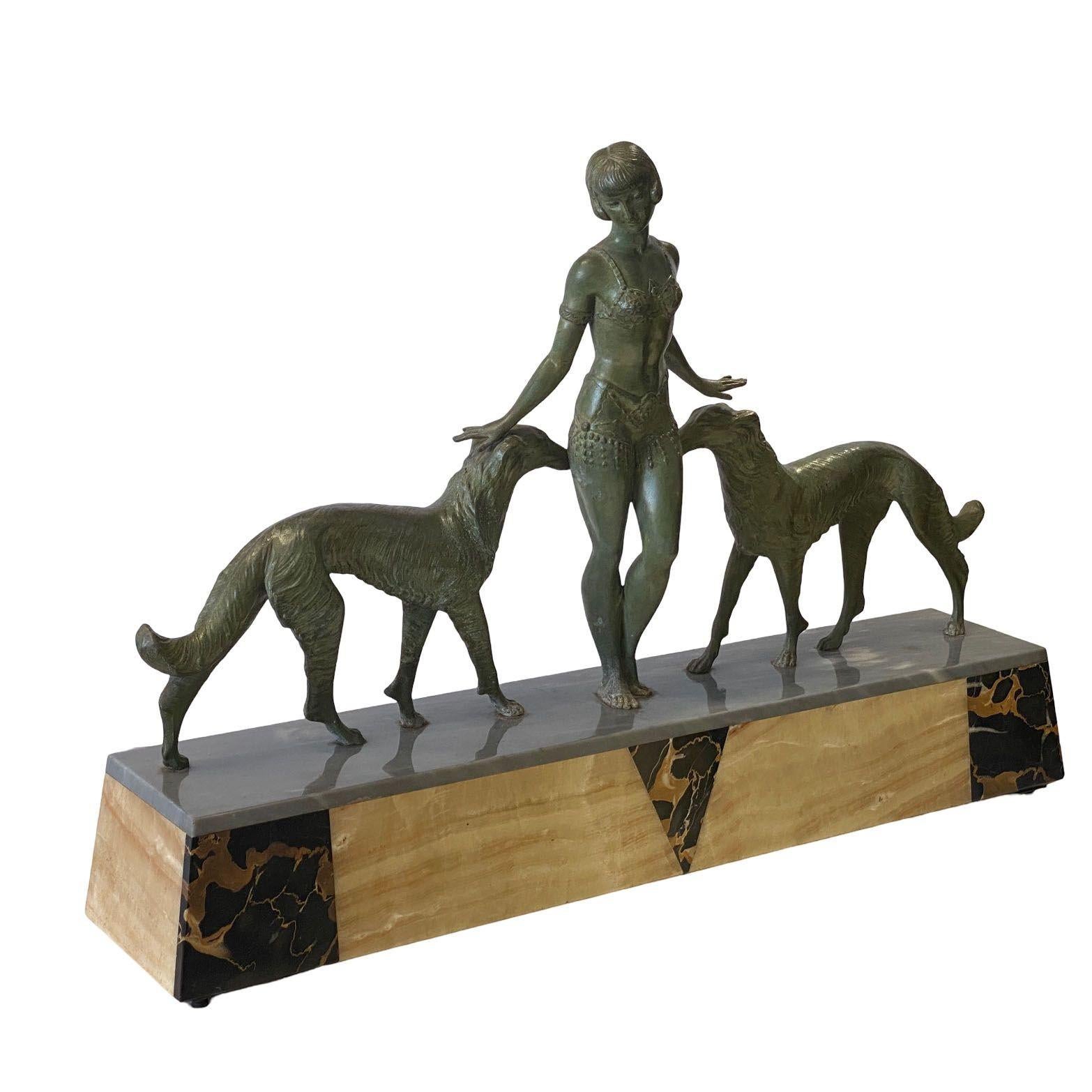 Illumina il tuo spazio con questa intramontabile scultura e lampada d'accento francese Art Deco che mostra una ragazza Flapper in bronzo con due cani Borzoi con patina verde fissata a una base di marmo multicolore.

La scultura è stata realizzata da
