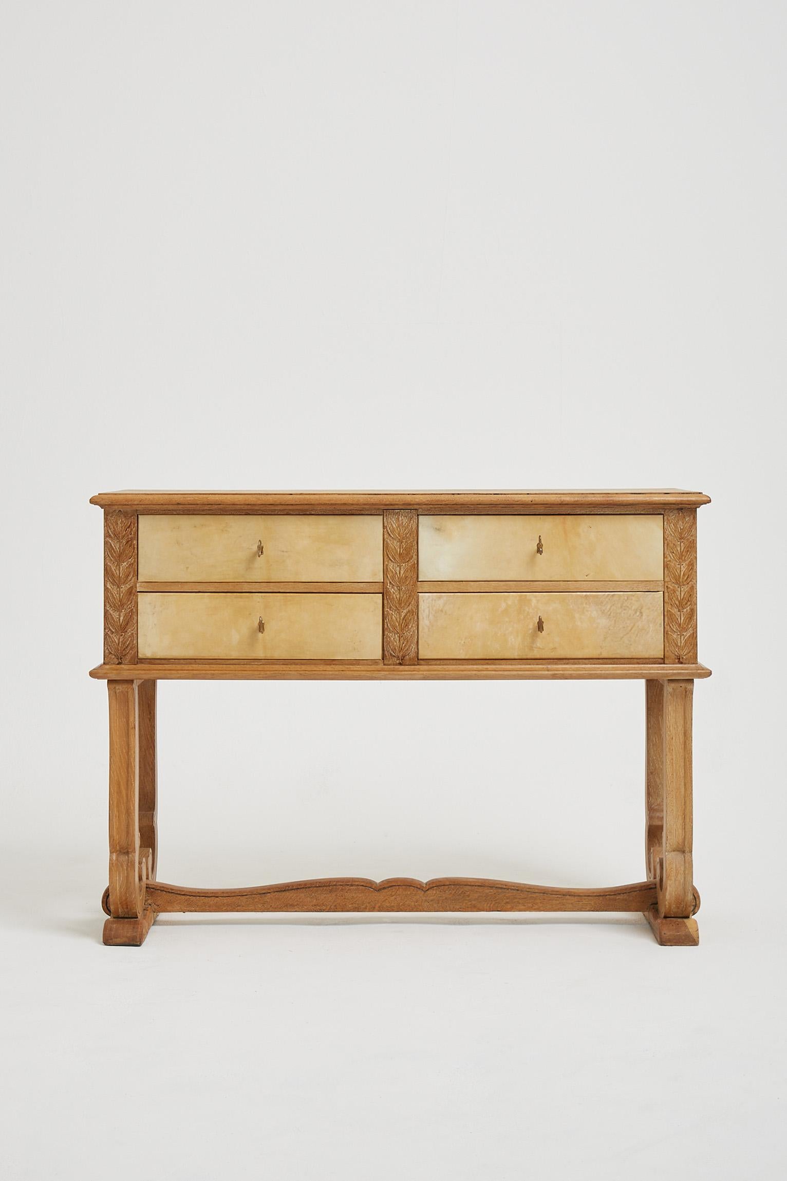 An Art Deco limed oak and velum chest of drawers, adorned with carved laurel leaves, on an elegantly shaped base. Stamped JP at the back (possibly Jean Pascaud?)
France, Circa 1930.