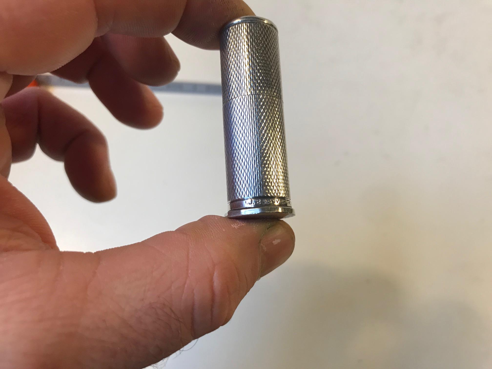 Ein kleiner Lippenstifthalter aus 830/1000 Silber. Aufwendige Guillochierung am Rand. Es wiegt etwa 50 gr. und ist vom Hersteller signiert und mit der Punze 830 versehen.