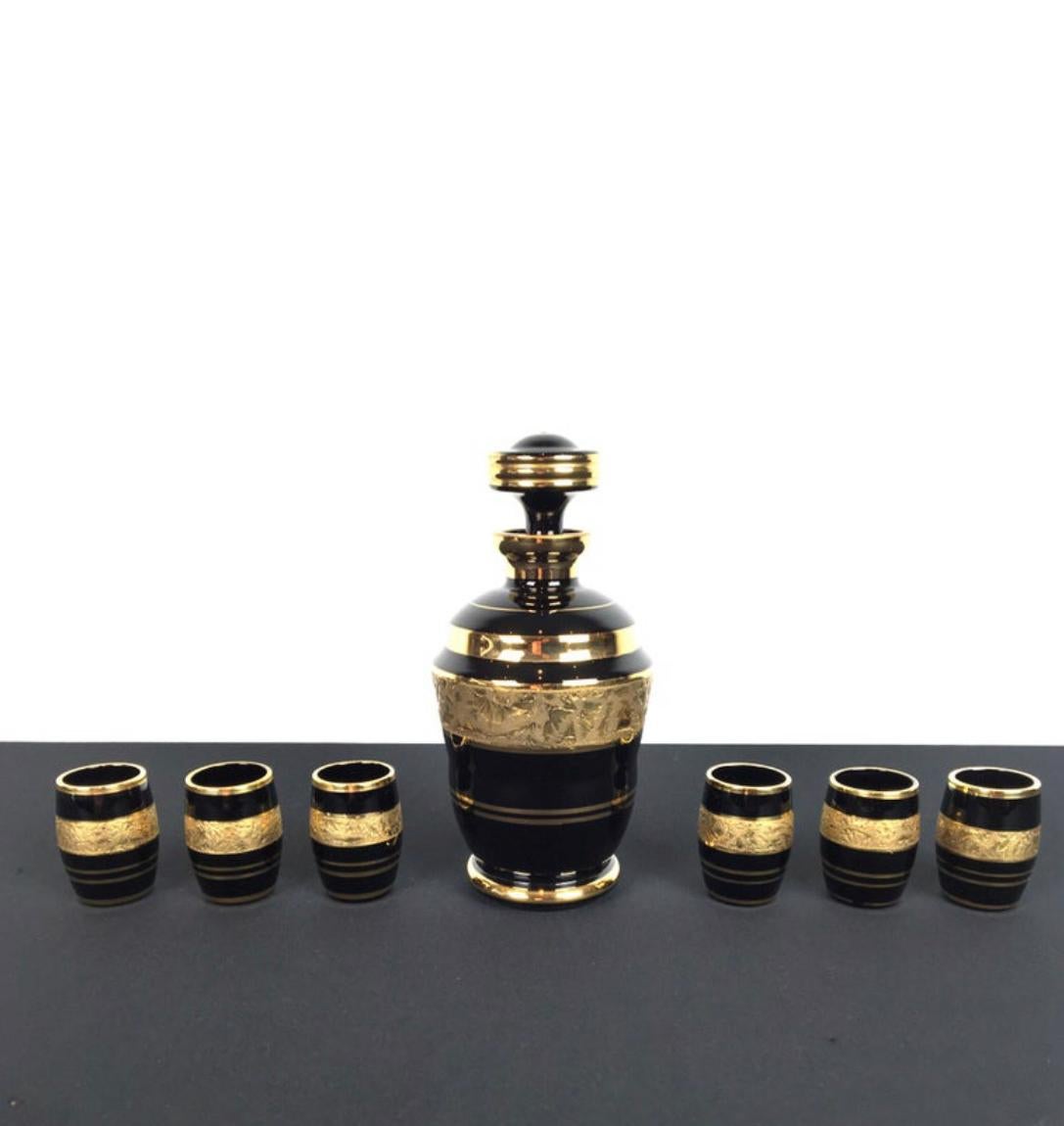 Art Deco liquor set in black and gold by De Rupel Boom Belgium. 
Black with gold carafe or decanter bottle with stopper and 6 glasses designed by Paul Heller. 
This 