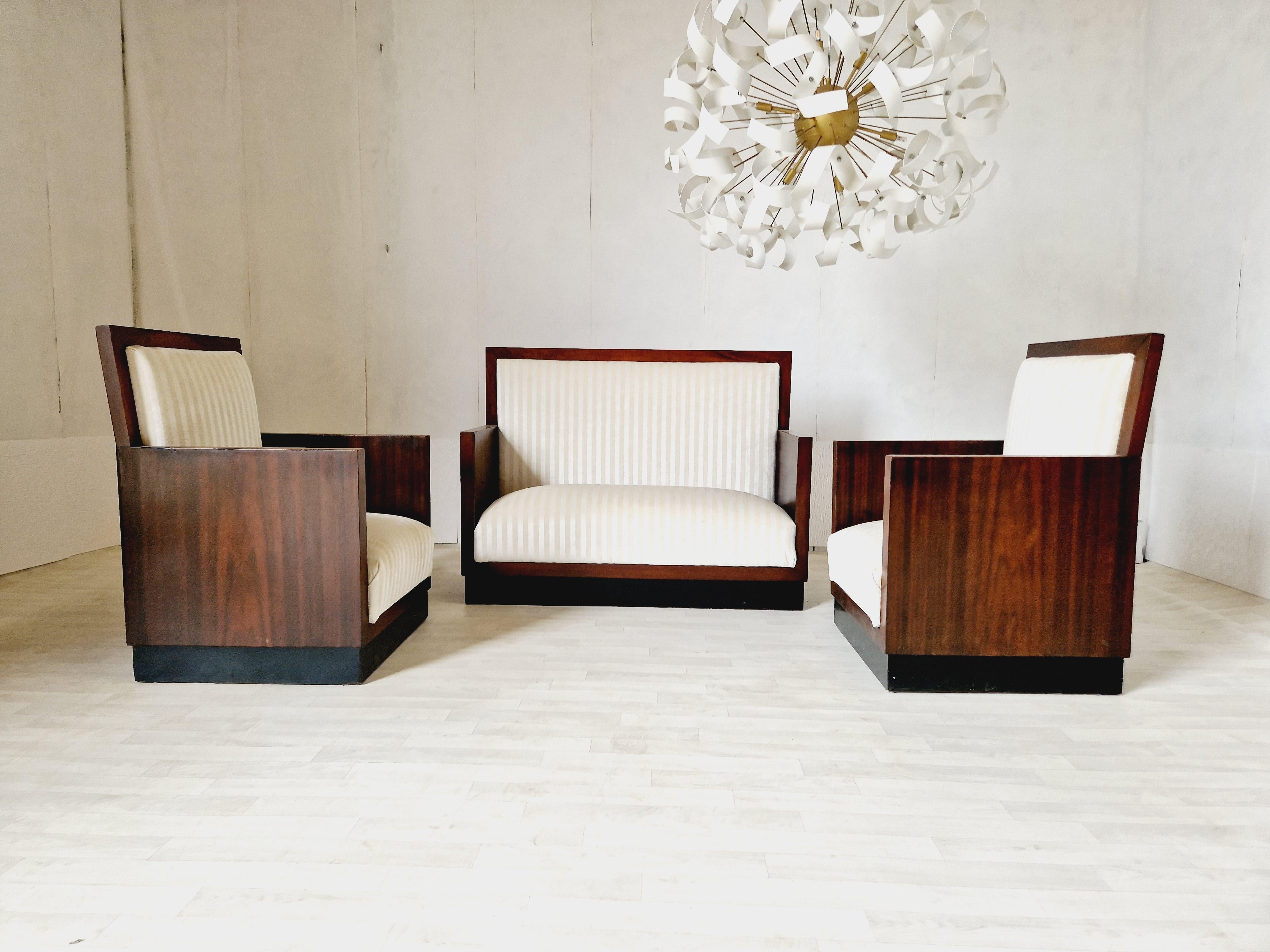 This vintage Art Deco living room set from the 1930s features a beautiful cube style design with a cream colour finish and Rosewood veneer. This set includes three chairs made of Rosewood and upholstered with luxurious chenille fabric. The chairs