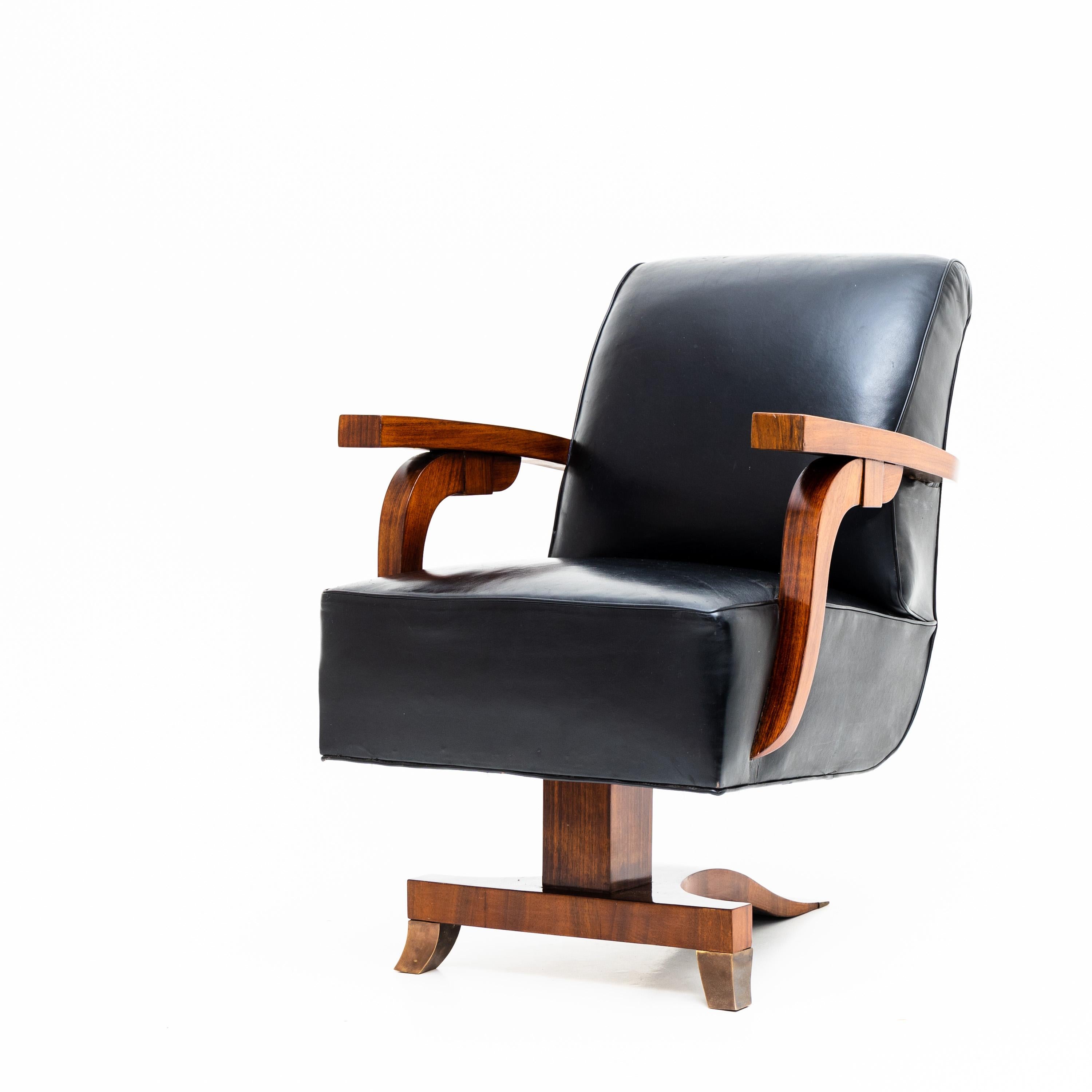Art Deco lounge chair with leather upholstery and elegantly constructed frame and armrests, veneered in mahogany.