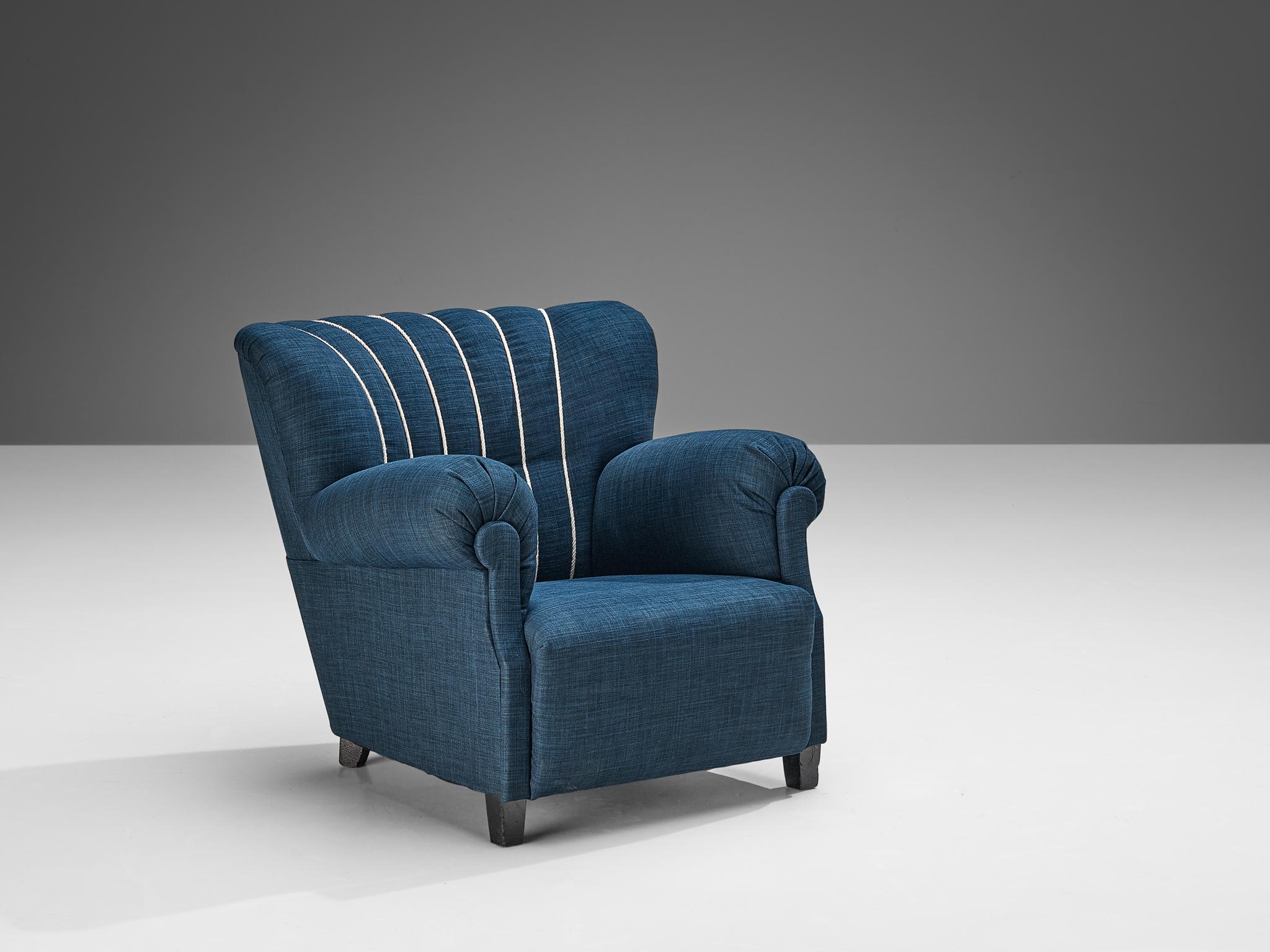Lounge chair, wood and blue upholstery, Europe, 1940s

This fine lounge chair undoubtedly breathes the late art deco period of the 1940s. The design has a certain theatrical aesthetic with curved armrests flowing slightly outwards. The chair is