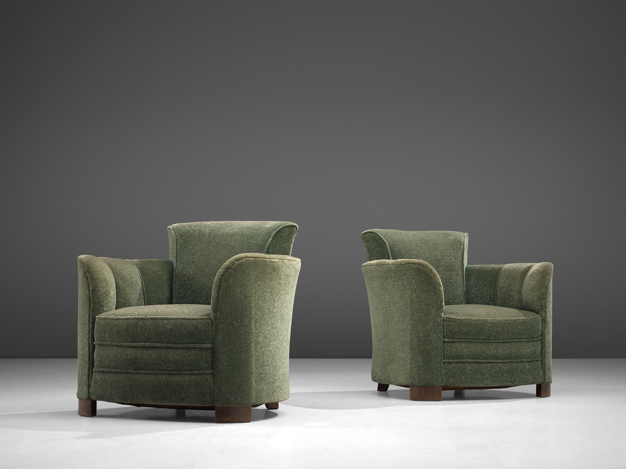 Pair of lounge chairs, oak and green velours, France, 1940s.

Rounded, comfortable chairs with a high back in a green fabric upholstery. The chairs are modest yet very well designed with the upswooping armrests and the almost perfect rounded chape