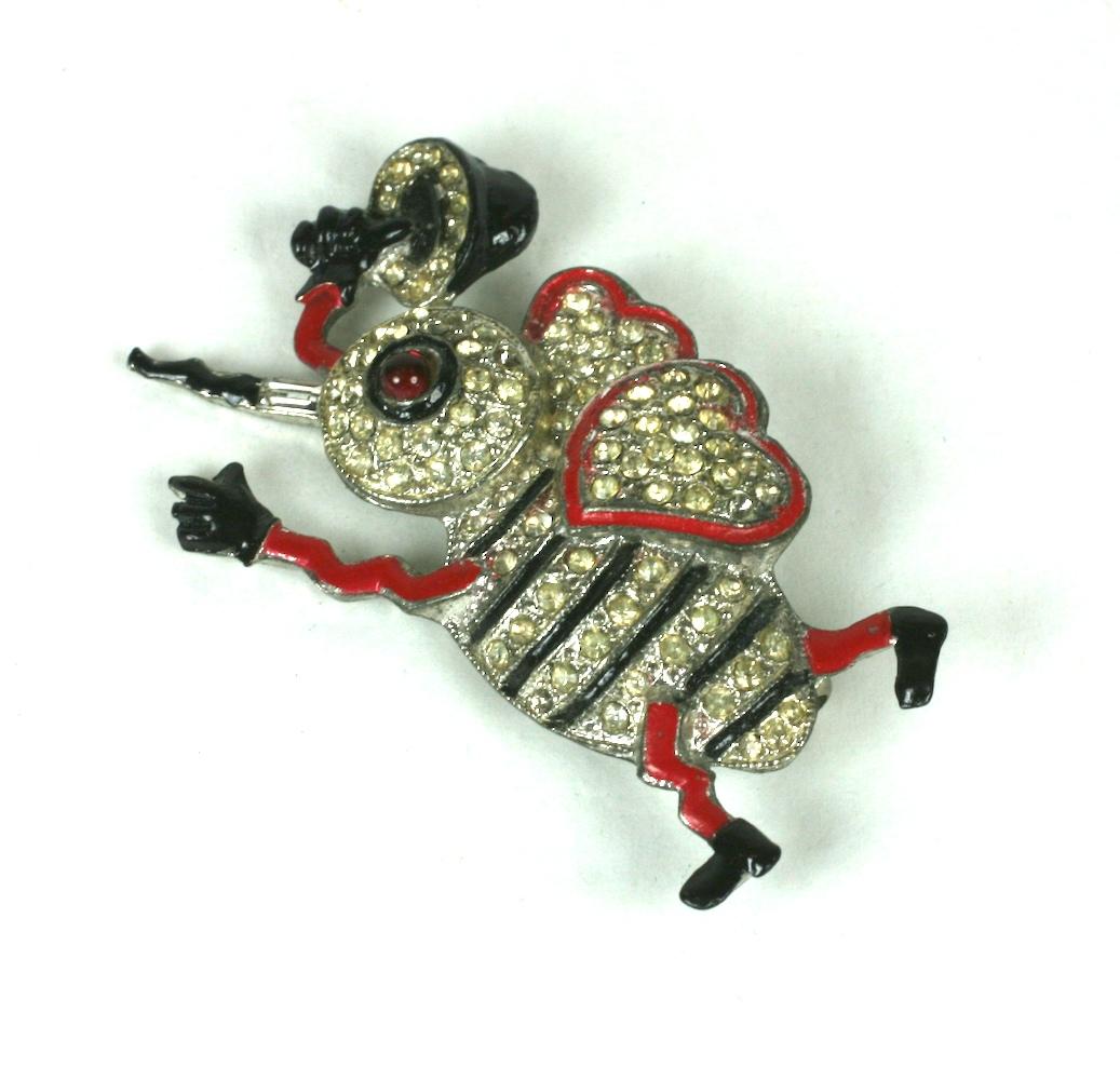 Charming Art Deco Love Bug Brooch from the 1930's. This figural love bug brooch with heart shaped wings is made of pot metal with enamel and crystal accents. He/she is ringing an enameled bell announcing his arrival. 
1930's USA. 
2.25