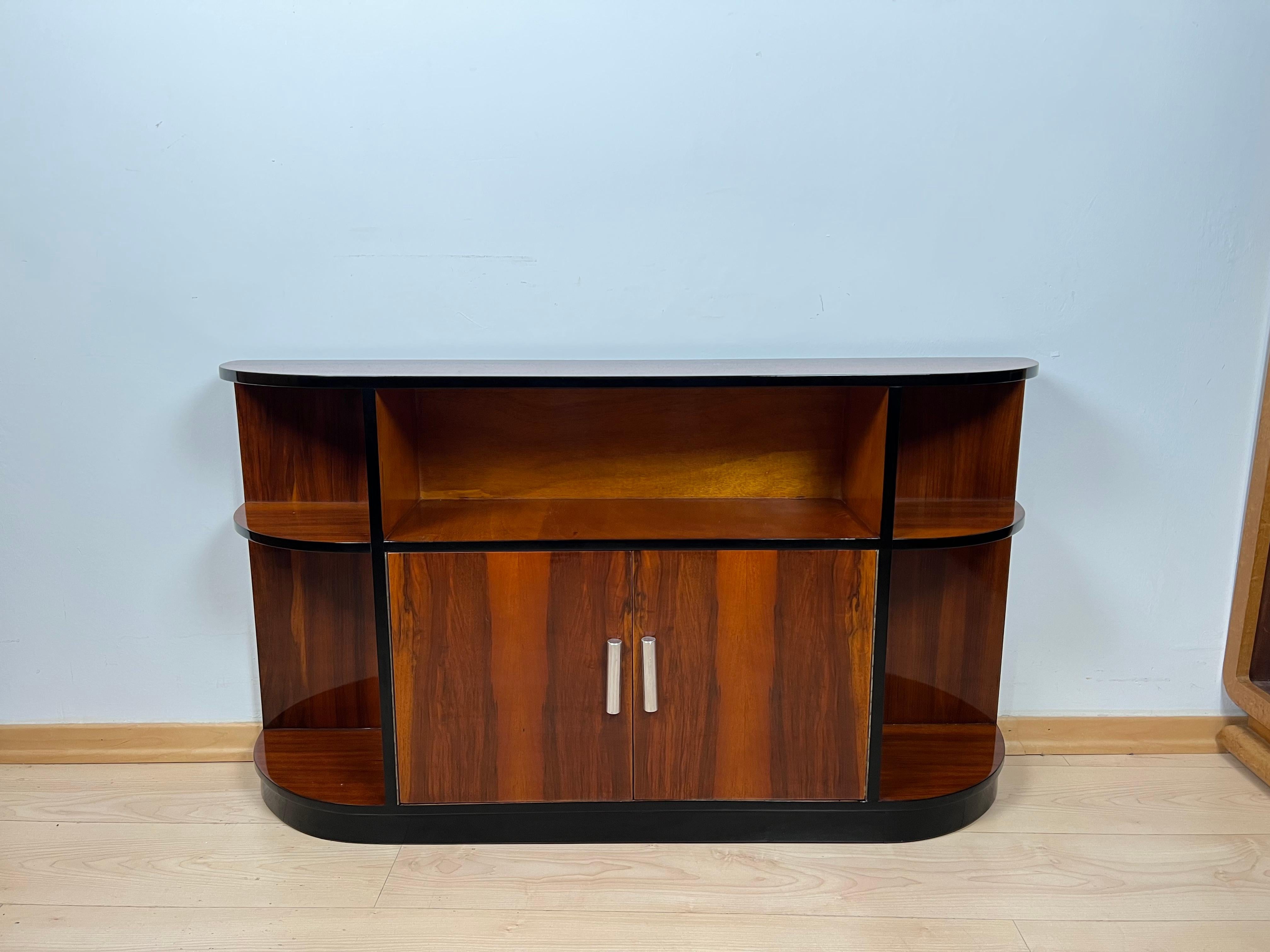 Art Deco lowboard with shelf, walnut Veneer, France circa 1930

Art Deco lowboard with shelving compartments. Walnut veneered and solid, partly ebonized parts. French polish finish. Open compartments and 2 doors with original cylindrical metal