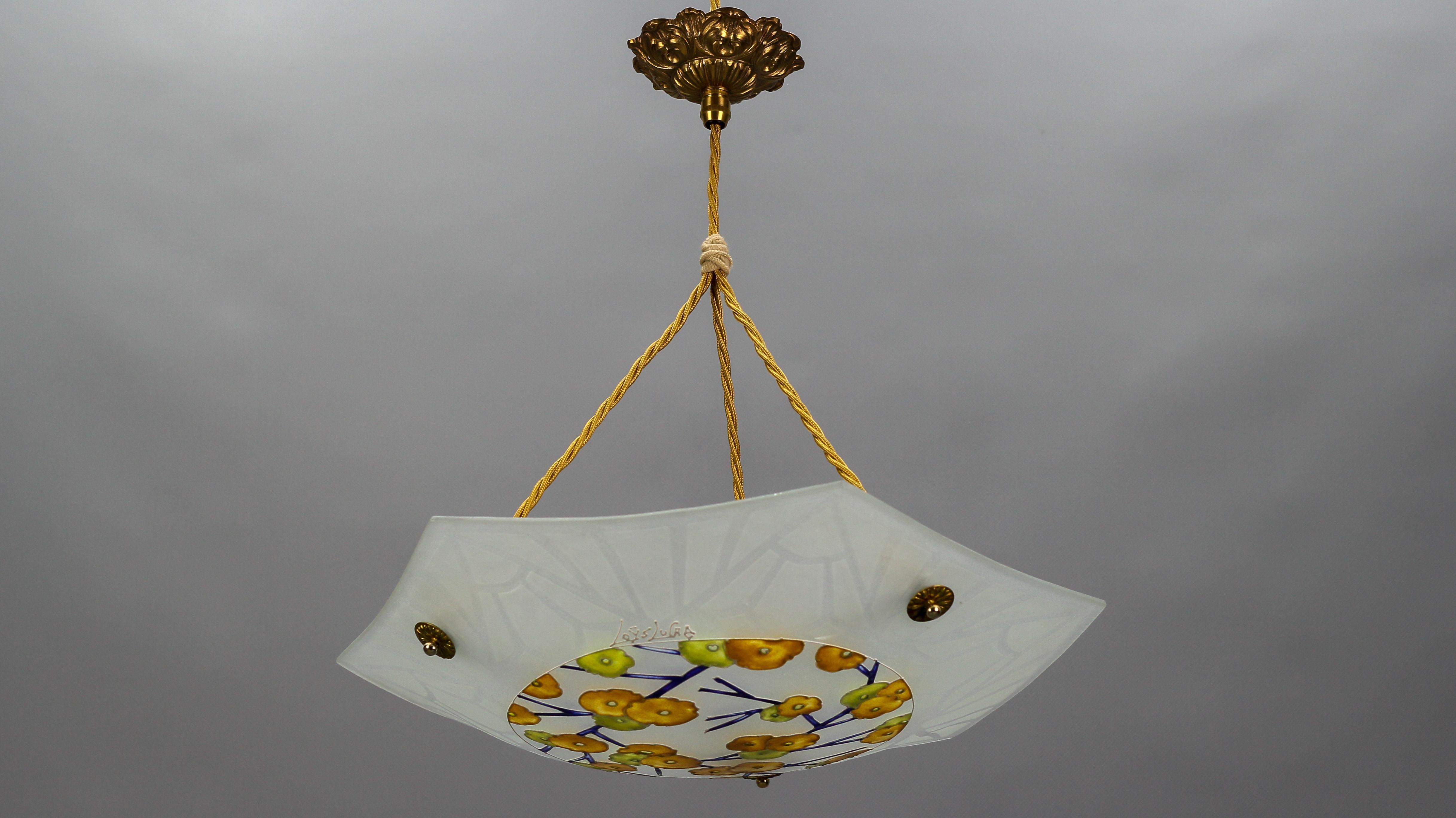 This beautiful Art Deco molded, frosted, and enamel-painted glass ceiling light features a floral design in yellow, orange, blue, and white colors, signed “Loys Lucha”. Outer edge is decorated with a geometric design. The colorful pendant light is
