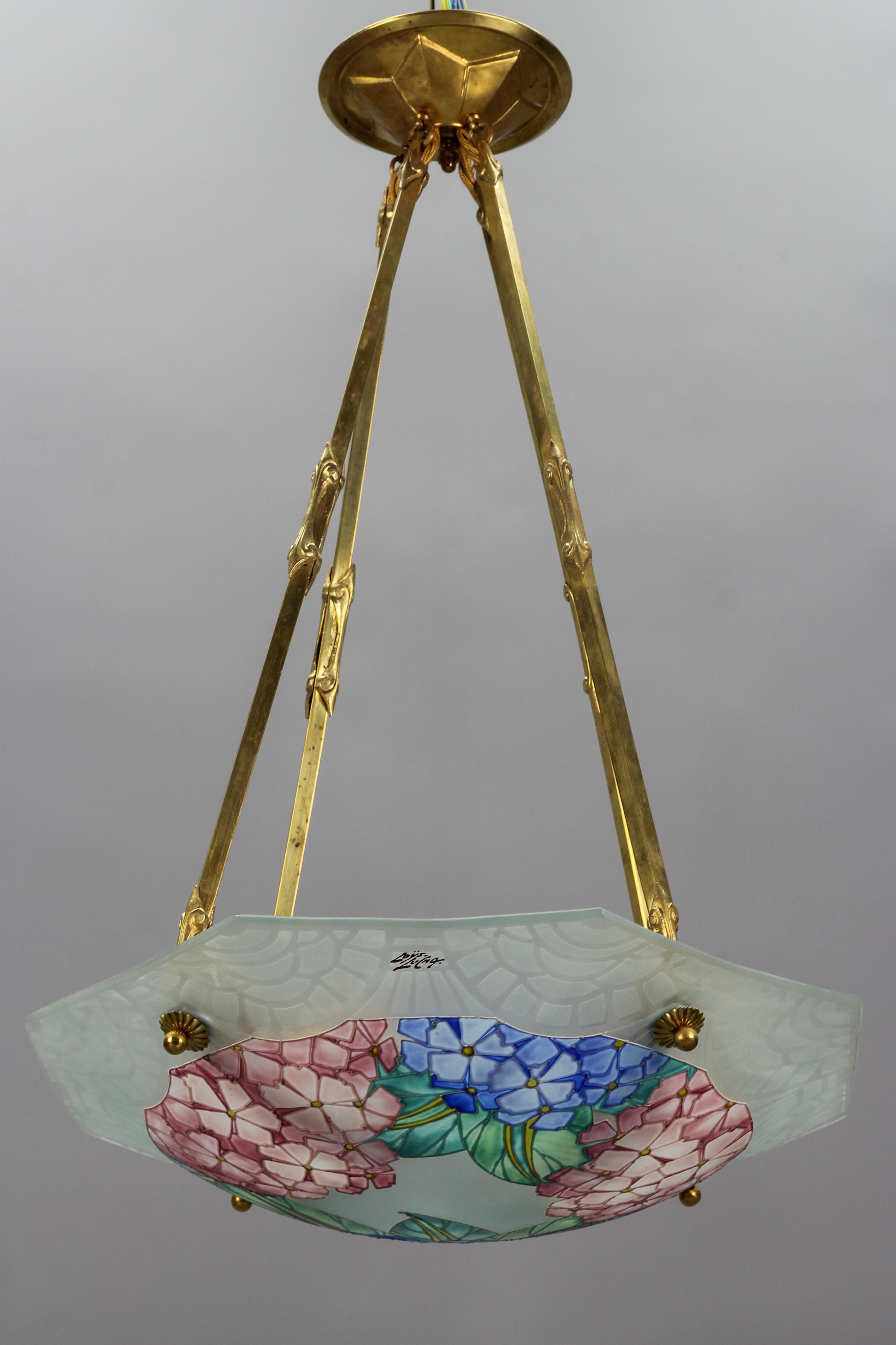 Cette superbe coupe octogonale Art Déco en verre moulé, dépoli et peint à la main présente un motif floral - des hortensias - dans des pastels doux - rose, bleu et vert - qui est magnifique aussi bien éclairé qu'éteint. Le bord extérieur est décoré