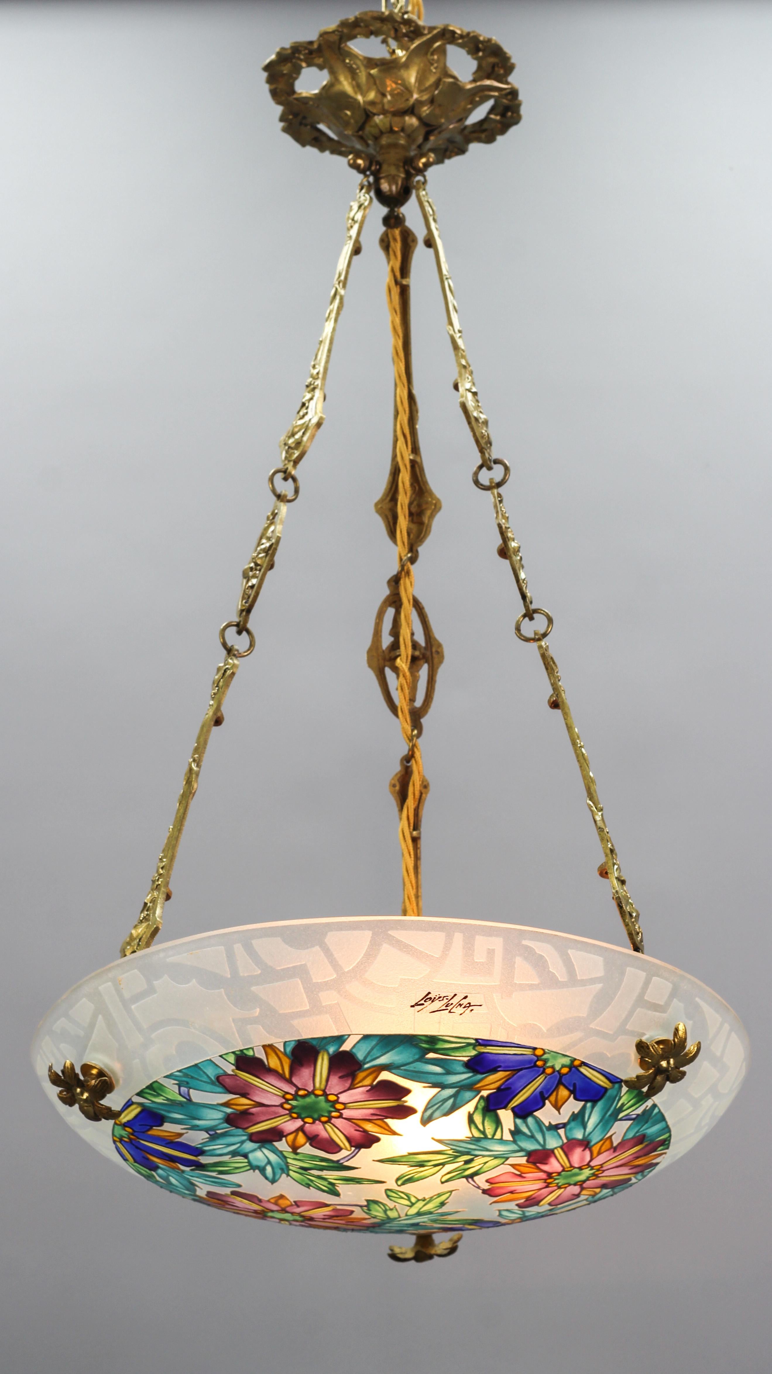 This beautiful Art Deco molded, frosted, and painted thick glass ceiling light features a floral design in purple, yellow, orange, blue, and green colors, signed “Loys Lucha”. The outer edge is decorated with a geometric design. The colorful pendant