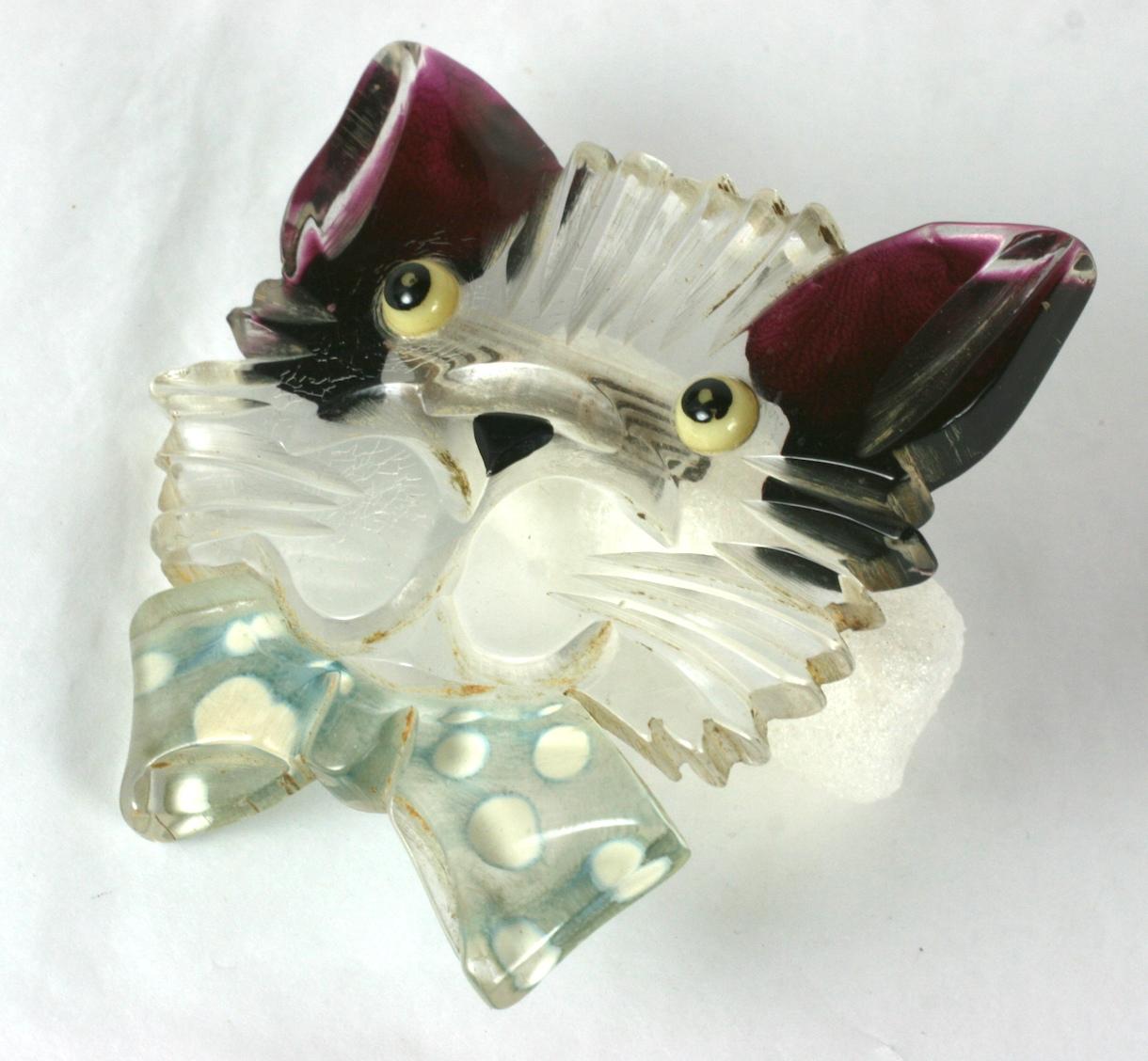 Charming Art Deco Lucite Cat Brooch from the 1930's. Cat is hand carved and reverse painted with highlights on ears and polka dot bow tie. Hand painted glass eyes. 1930's Folk Art, USA.
Excellent condition.  2.75