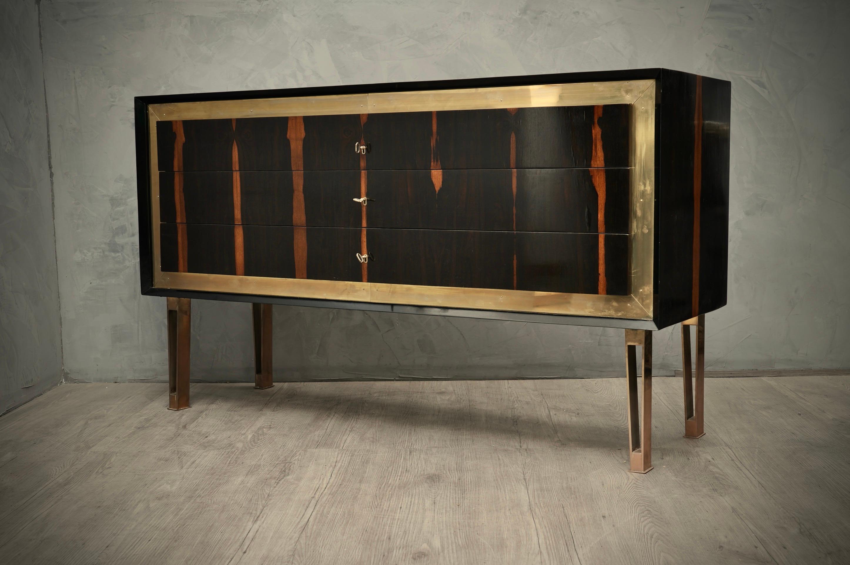 Linear, square but very elegant, the commode has a very particular design also due to the fact that it is made with quality materials, walnut wood and polished brass.

Body entirely veneered in walnut wood with a beautiful grain, and a beautiful
