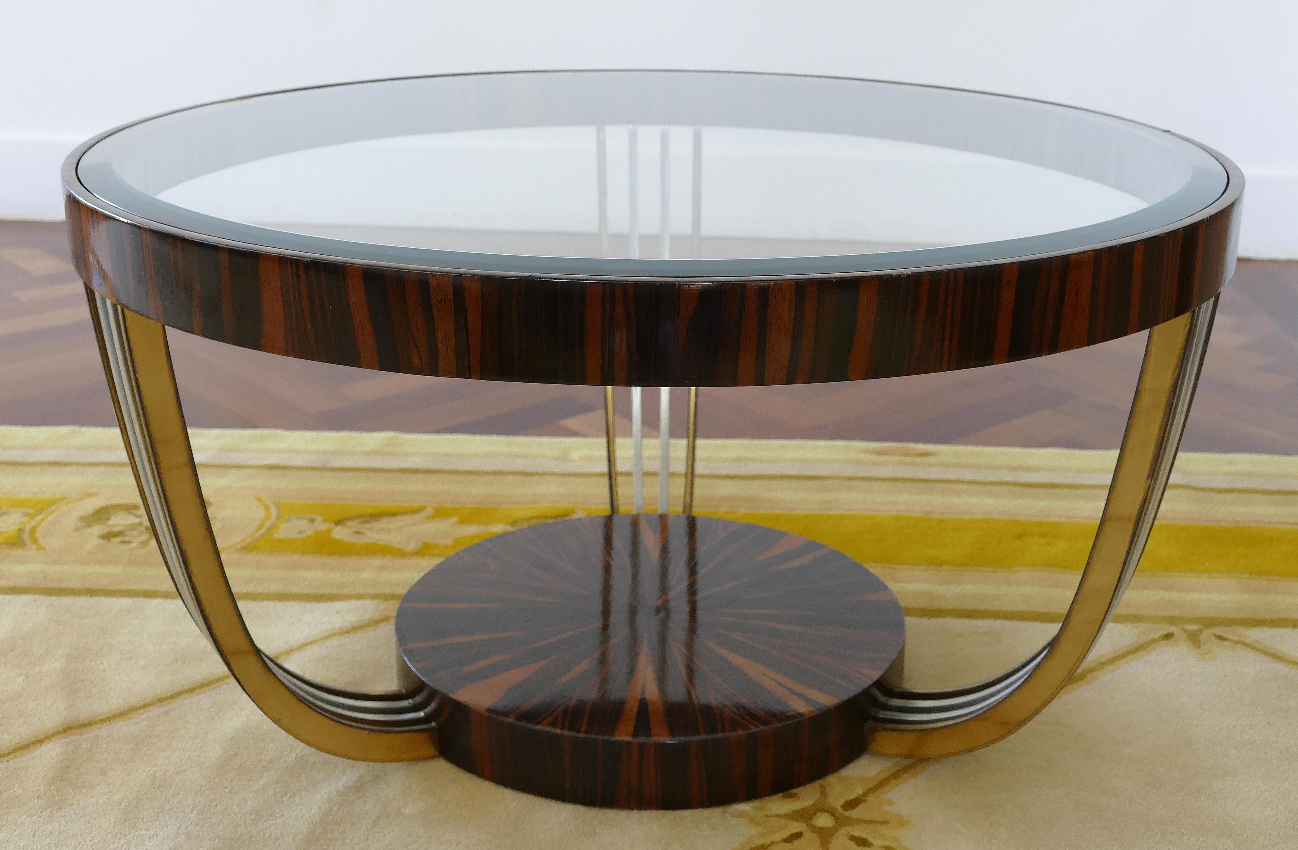 Art Deco Macassar brass and chrome coffee table with an inset beveled glass top

Offered for sale is a round period Art Deco Macassar wood coffee table with brass and chrome accents. The table has an inset beveled glass top. The round base has a