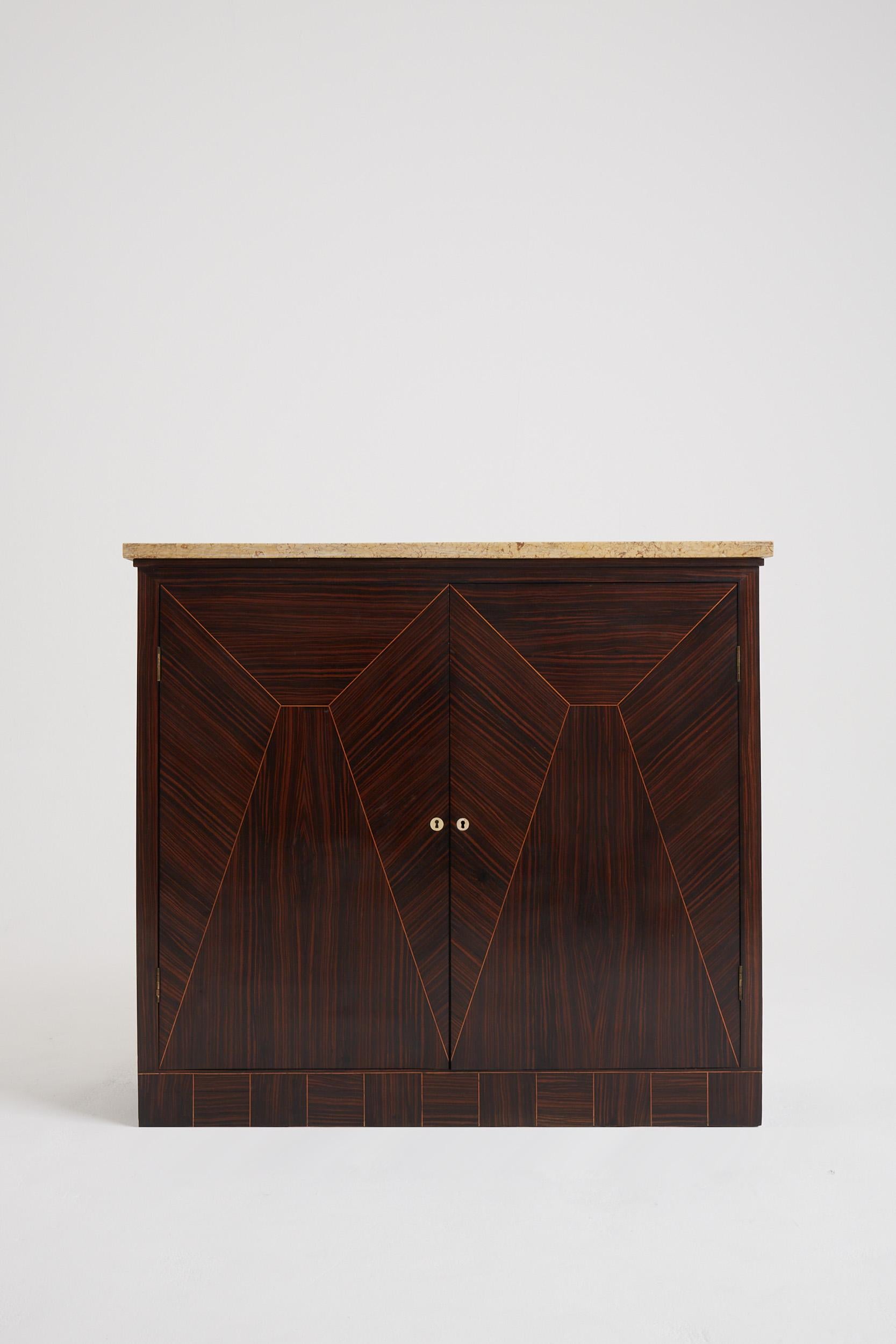 An Art Deco Macassar ebony and stone top cabinet, with a superb geometric marquetry and bone key holes.
France, Circa 1930.