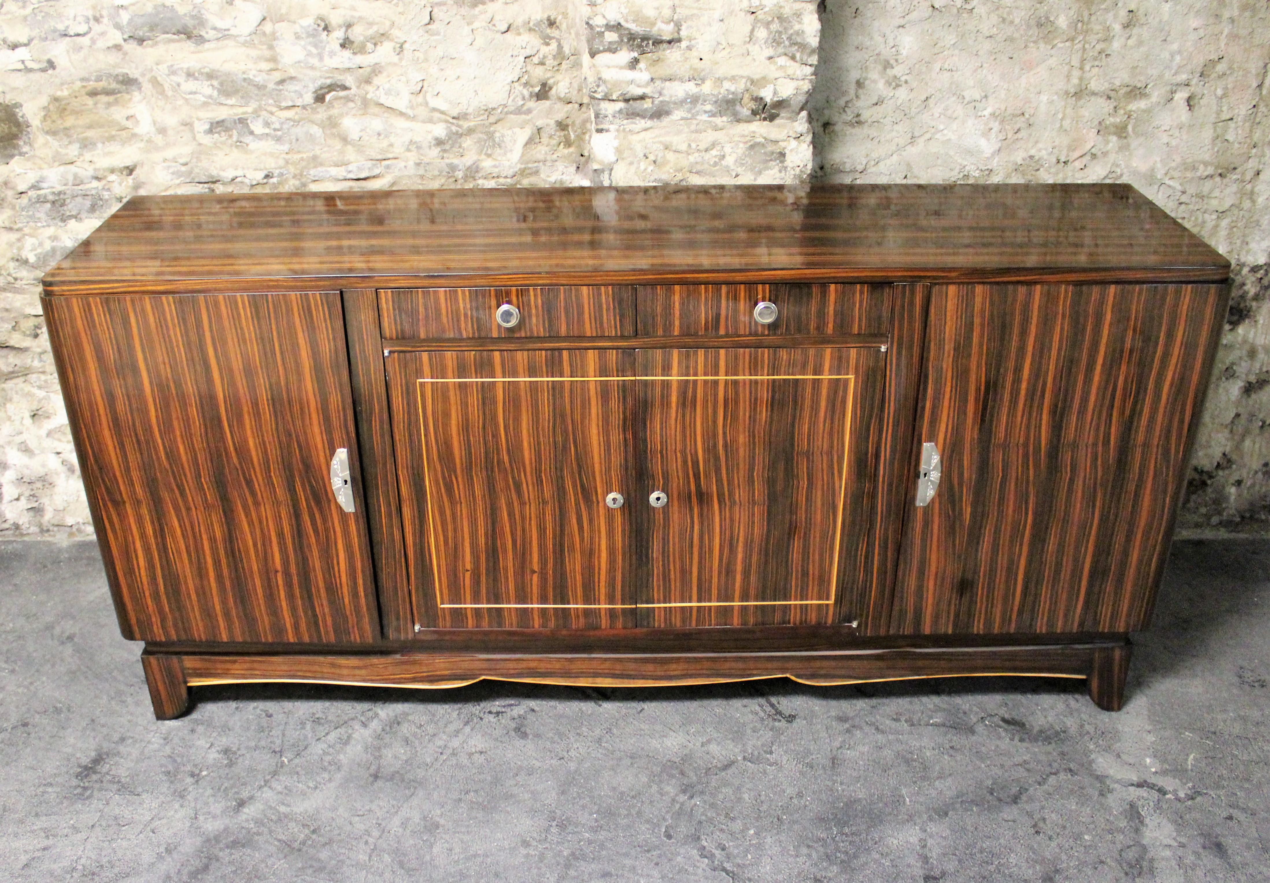 Art Deco Macassar ebony sideboard in the manner of Émile-Jacques Ruhlmann. This four-door and two drawer credenza is elegantly designed with chrome hardware and beautiful rich wood grains.