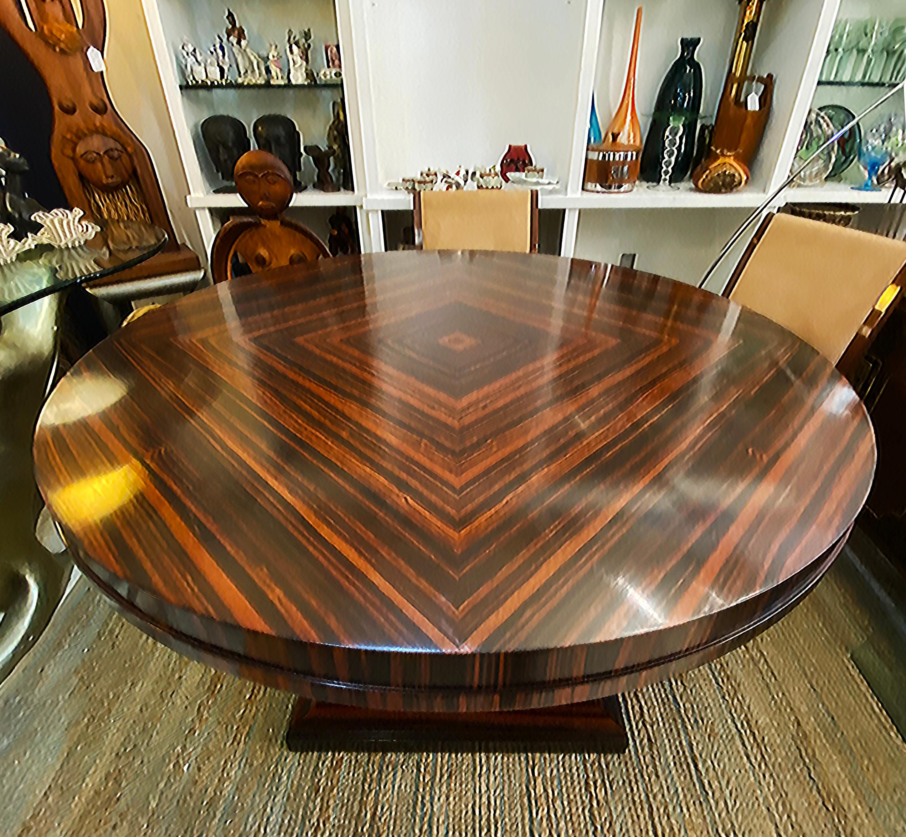 Art Deco Macassar Ebony Round Dining Center Table, Beautifully Veneered Wood

Offered for sale is a  wonderful round matched-grain macassar ebony center table or dining table. The table is created in the Art Deco style with a square base having four