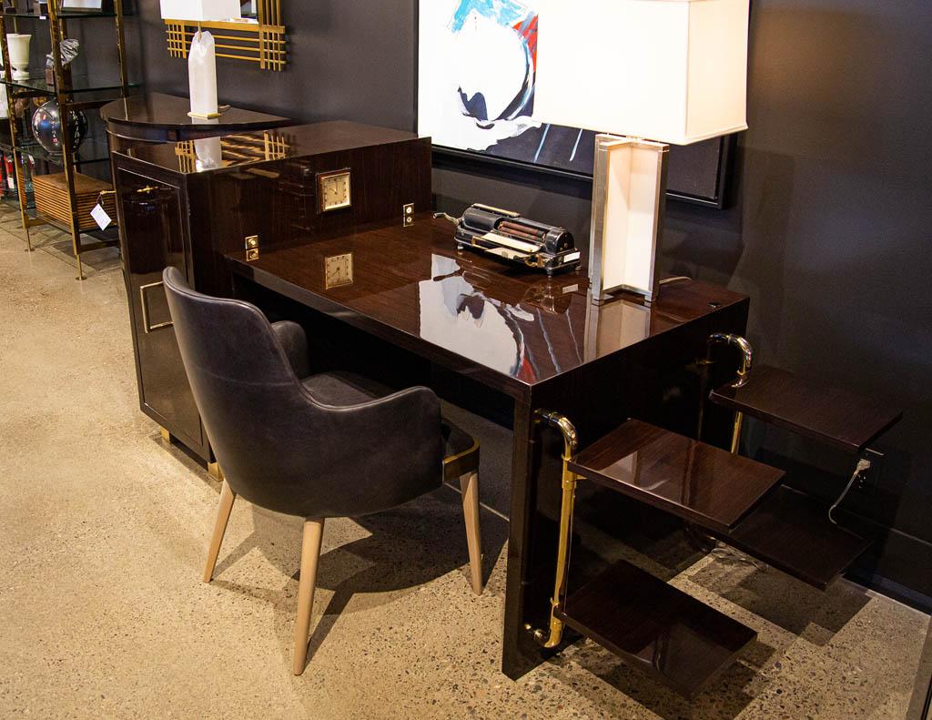 Art deco macassar executive desk. France, circa 1940’s. This iconic, stunning art deco creation is out of this world. Rich, luxurious macassar woods with polished brass accenting. Unique oversized door conceals a large hidden chest of drawers for