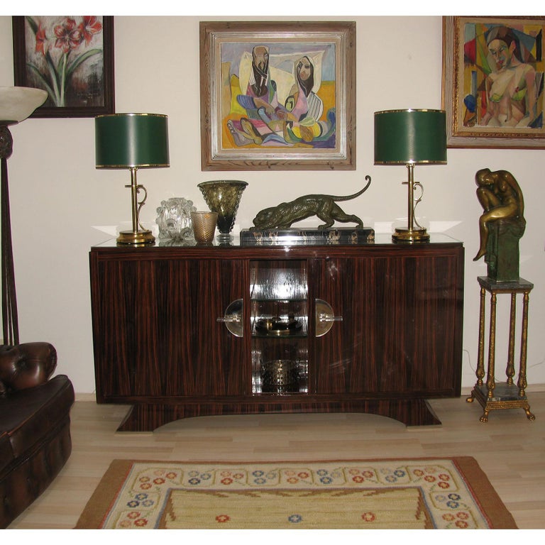 Art Deco Macassar sideboard, France 1940s.
Fabulous French Art Deco high gloss lacquer exotic Macassar with two doors to the sides and two center glass shelves. Glass handles fixed on nickel suport.
Arched base feet shaped, with nickel metal