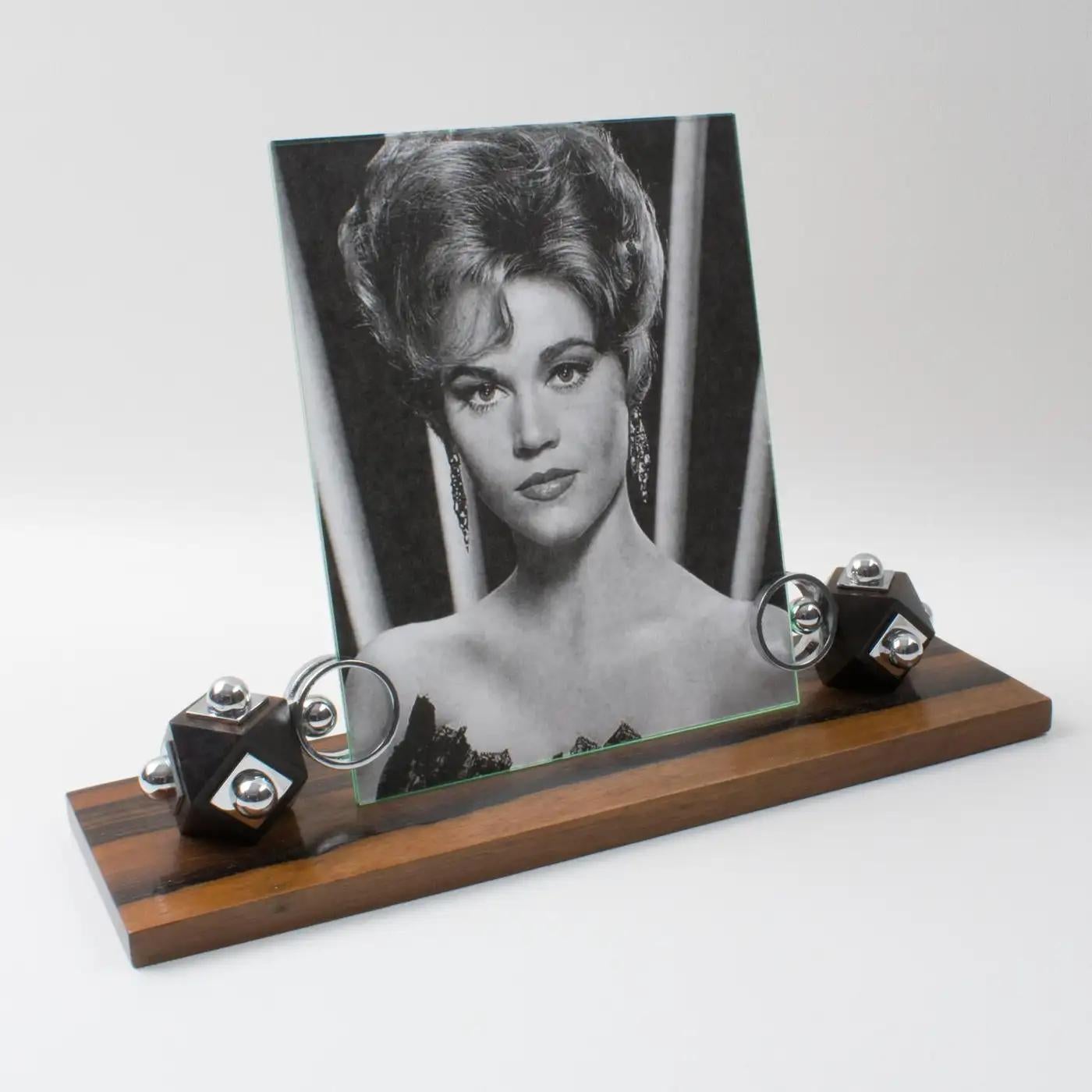 This Art Deco modernist picture frame features a thick hand-rubbed Macassar wood plinth complemented with cubic Macassar wood holders ornate with chrome accents. The photo frame is complete with two glass sheets to enclose the photography. There is