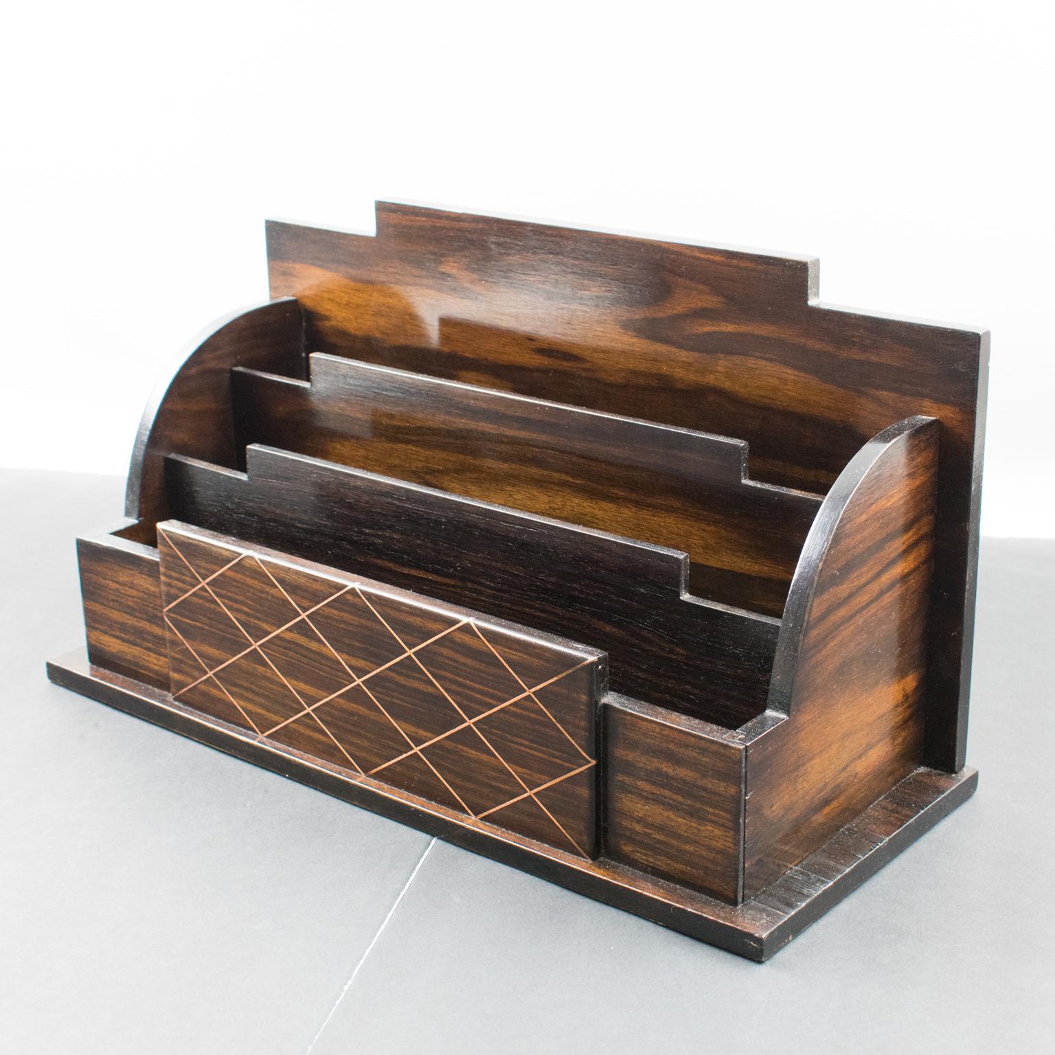 This elegant Art Deco modernist desktop accessory, a letter holder, was designed and crafted in France in the 1930s. With its typical Art Deco geometric shape, the mail accessory is made of Macassar wood veneer and copper metal pattern with a