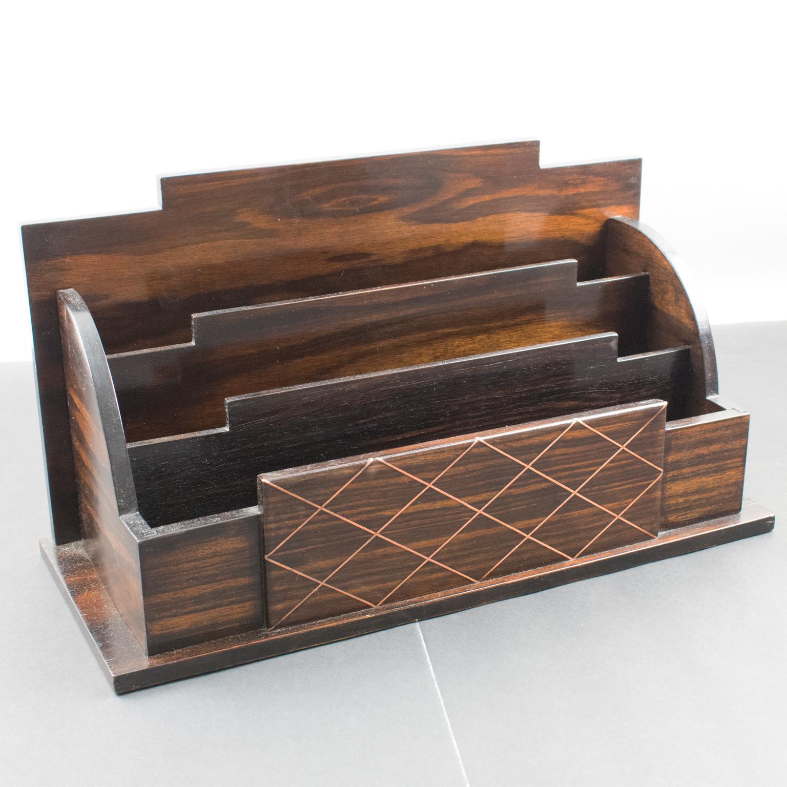 This elegant Art Deco modernist desktop accessory, a letter holder, was designed and crafted in France circa 1930. With its typical Art Deco geometric shape, the mail accessory is of Macassar wood veneer and copper metal pattern with a lattice inlay