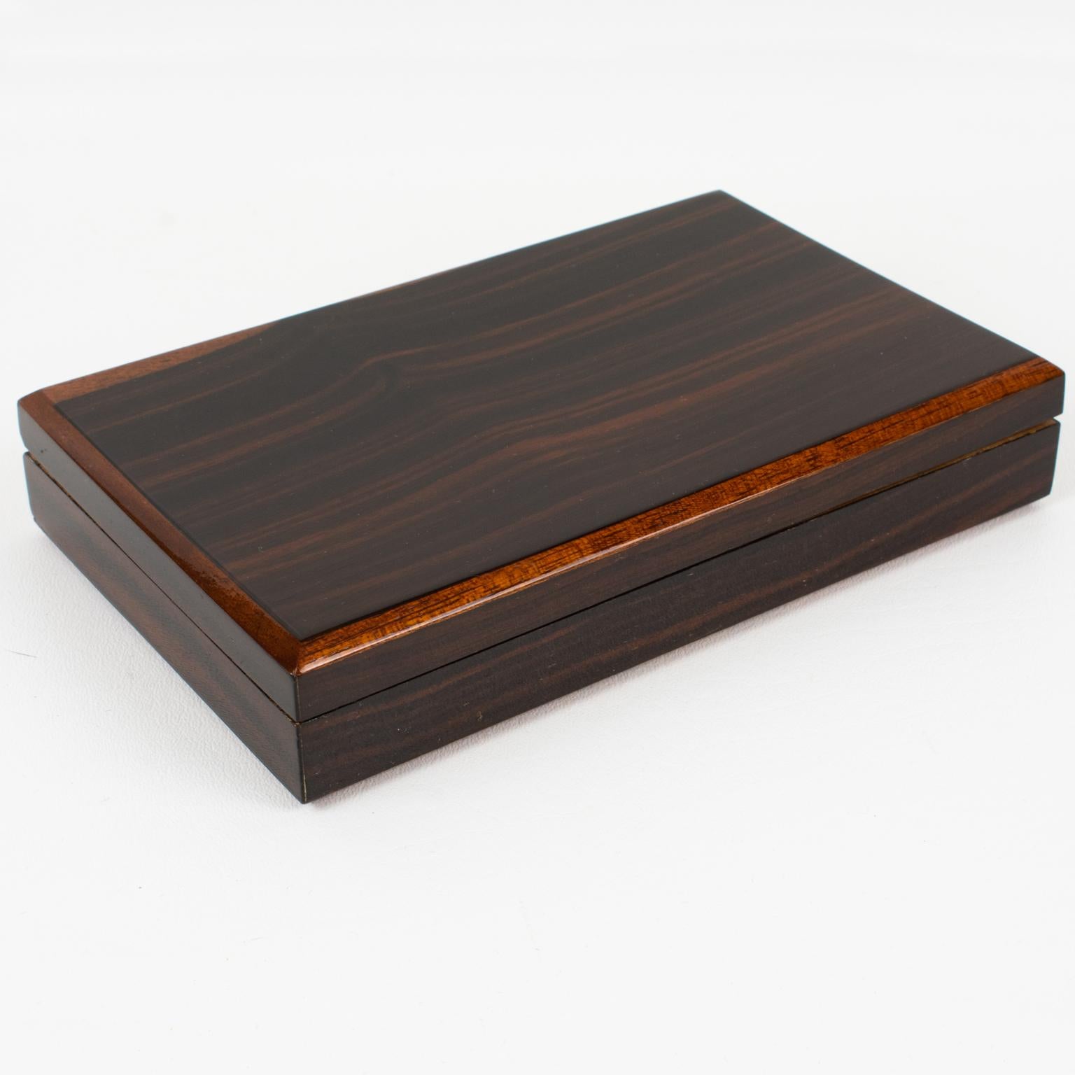 This elegant French Art Deco modernist decorative lidded box boasts a minimalist yet refined and sophisticated shape with varnish Macassar wood ornate with tropical wooden edging trims. The interior of the object is adorned with tropical wood