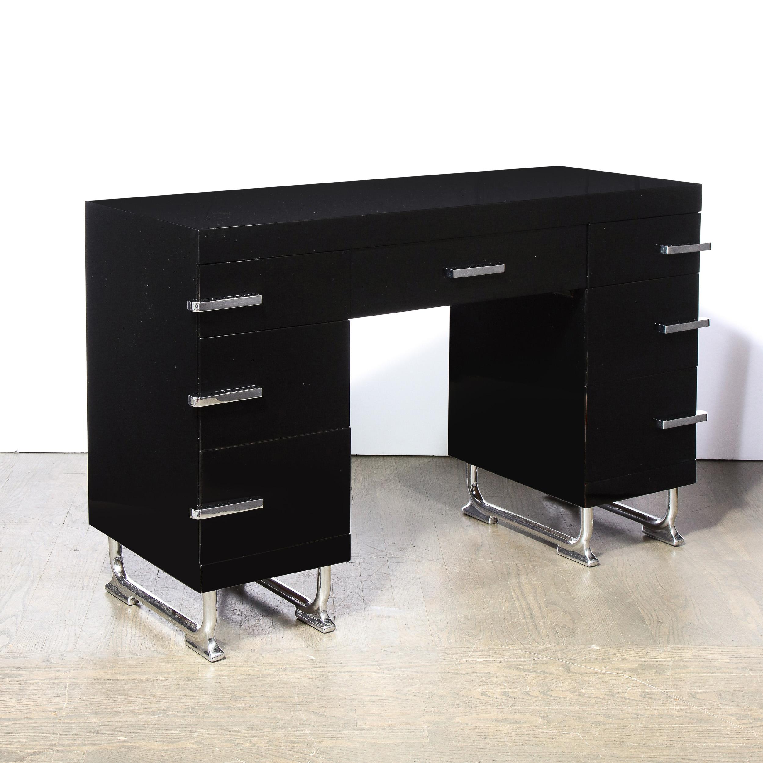 This stunning Art Deco Machine Age black Lacquer desk was realized in the United States, circa 1935. It offers a central drawer with three additional drawers on each side all fitted with streamlined chrome pulls. The piece sits on a stylized