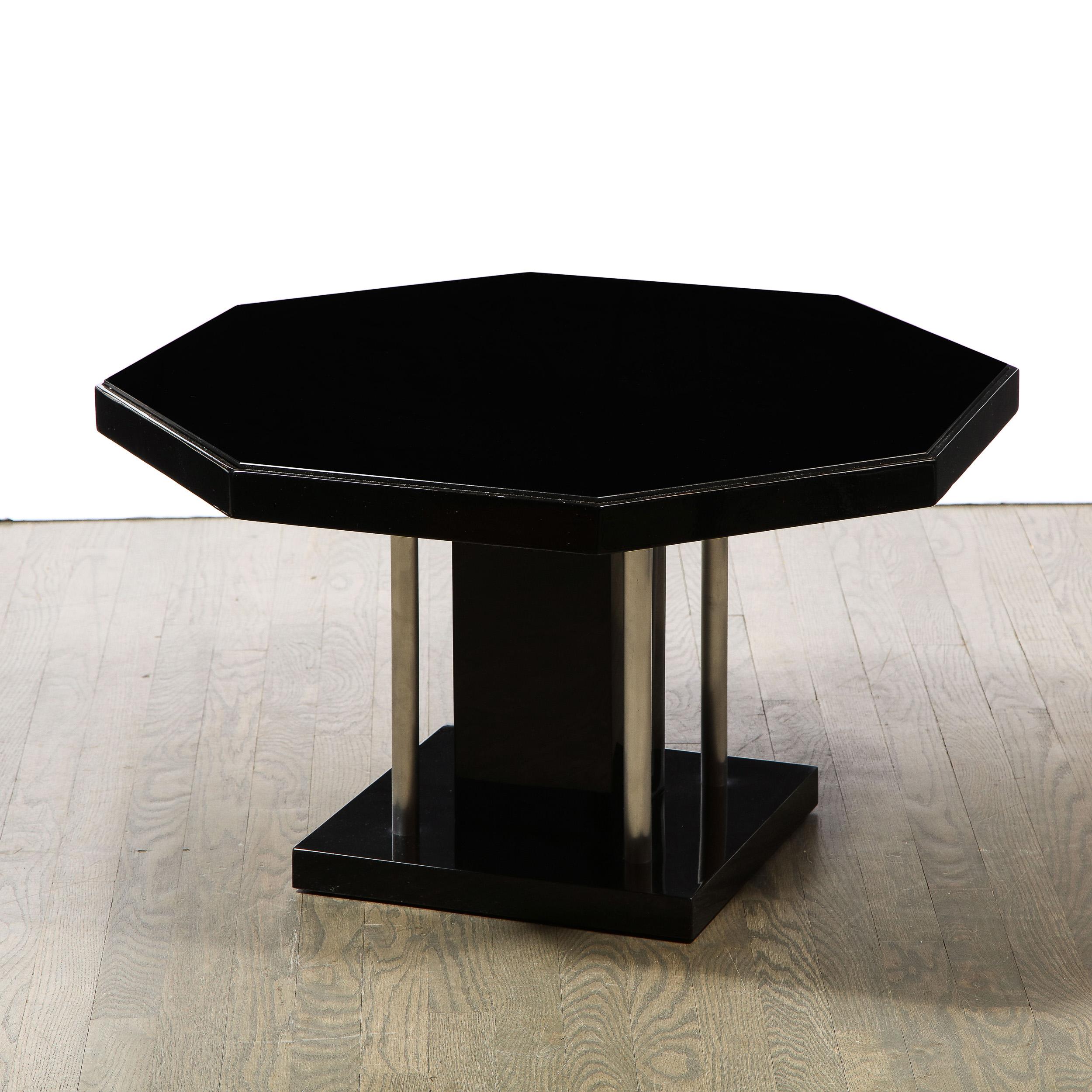 This stunning Art Deco Machine Age cocktail table was realized in the United States circa 1935. It features a square base; a volumetric rectangular body and an octagonal top- all in lustrous black lacquer- with a vitrolite inset. Additionally, the
