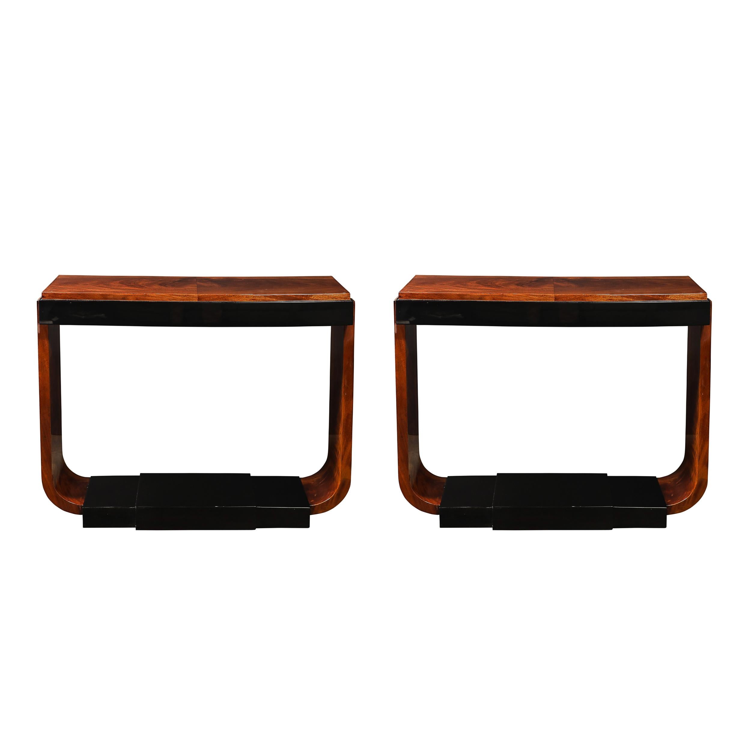 This striking pair of Art Deco Machine Age console tables, crafted in America circa 1935, exemplifies the bold geometric elegance and streamlined sophistication of the era. Constructed in book-matched walnut with a stunning pattern on the top