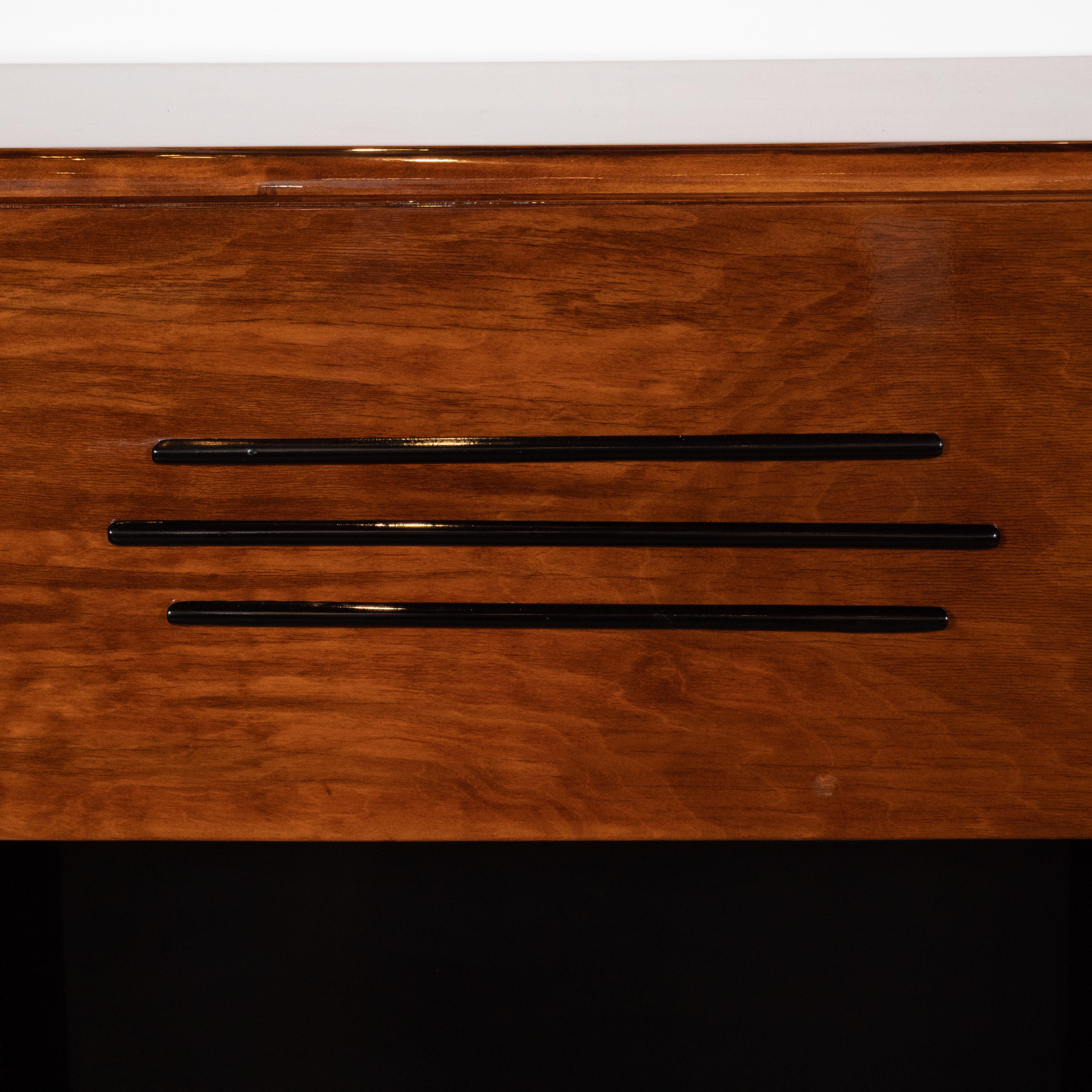This elegant Art Deco Machine Age streamlined fireplace was realized in the United States, circa 1935. It features a rectilinear body, realized in bookmatched walnut with a black lacquer interior and inset sides in the same material with banded