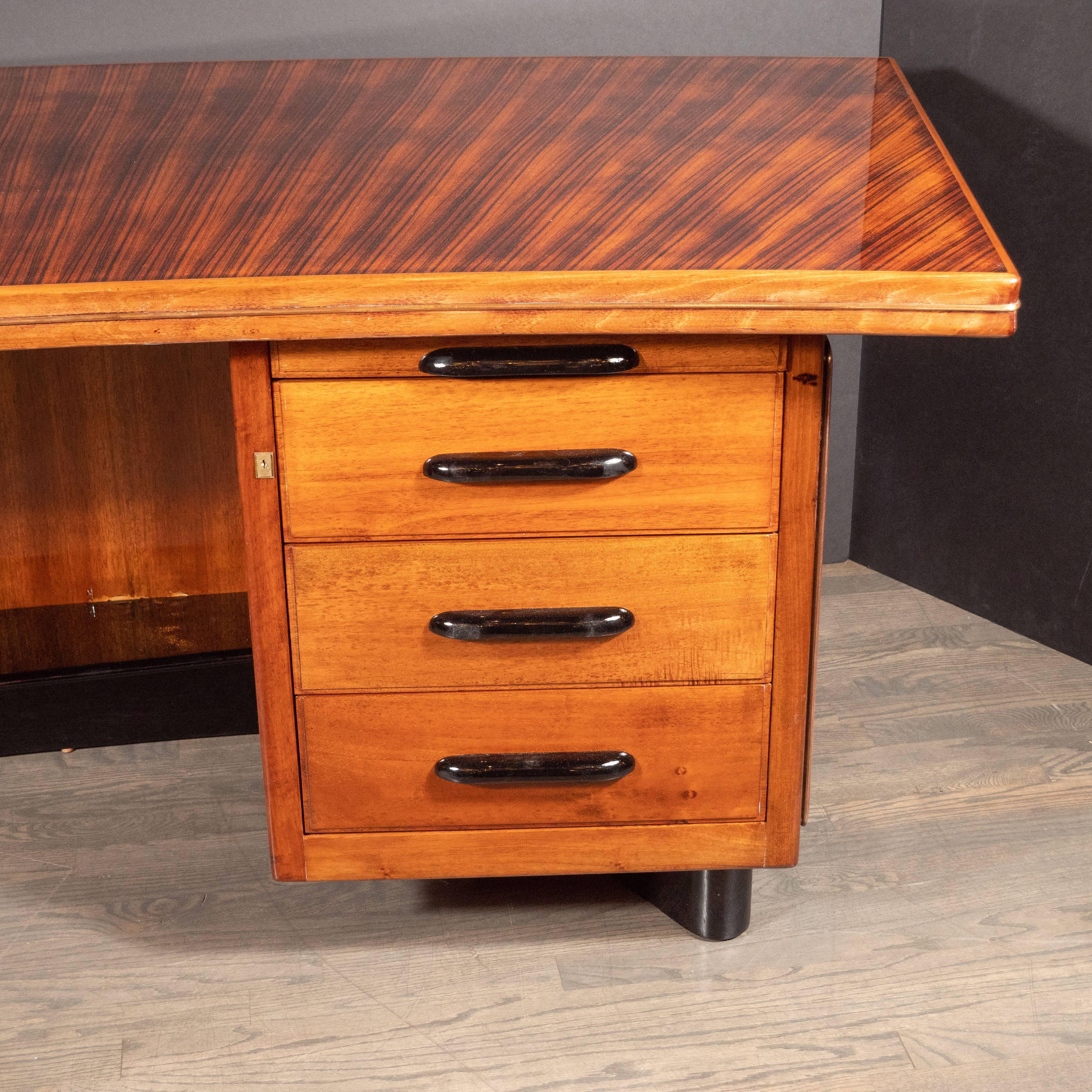 This stunning and elegant desk was realized in the United States, circa 1940. Composed of a classic streamlined bow front form, the top, sides and back of the piece has been created in bookmatched rosewood offering a dramatic grain. The interior of
