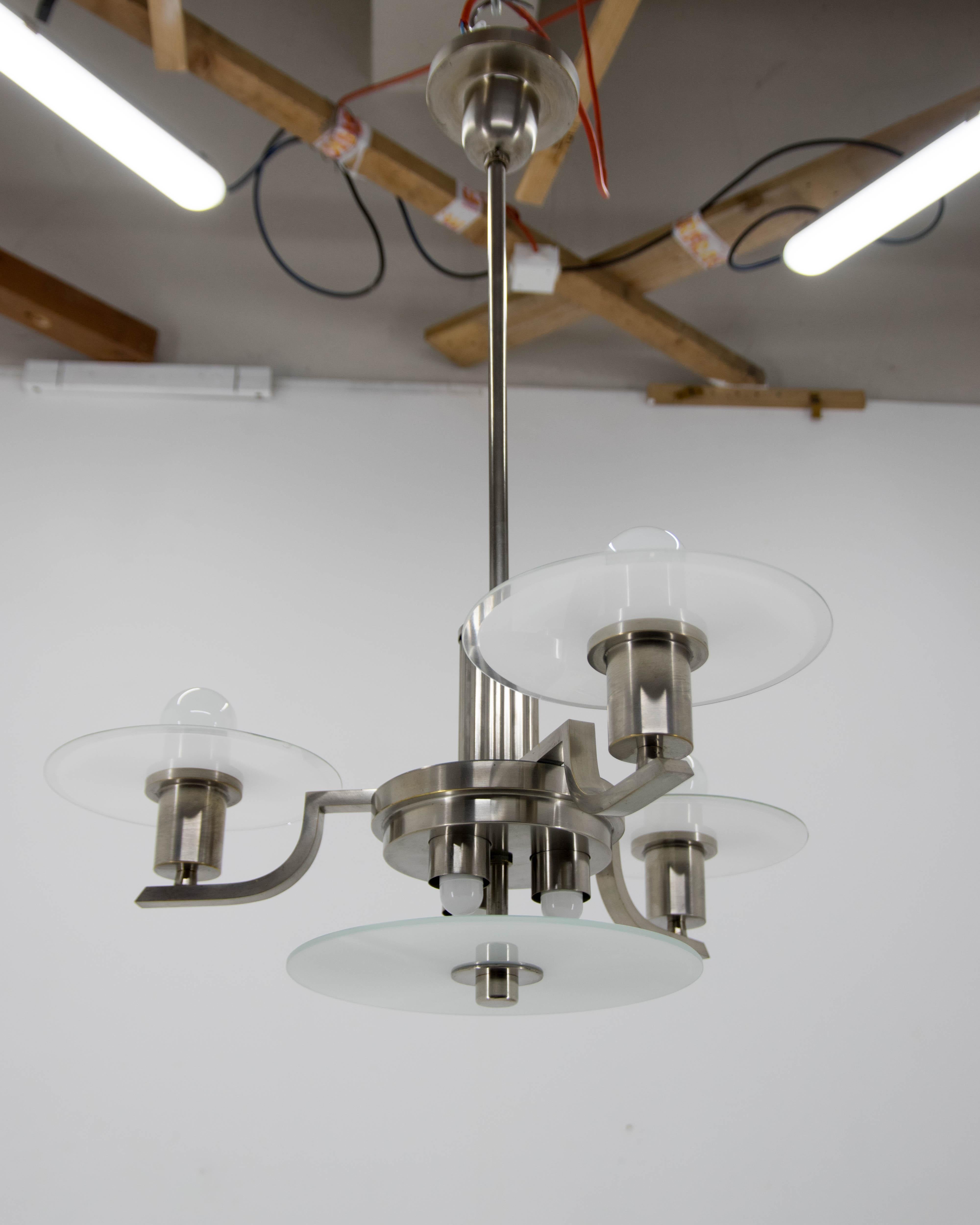 Machine Age chandelier made of nickel-plated brass and glass.
Restored, polished, rewired:
Two separate circuits - 3x25W (E12-E14 bulbs on the bottom part)
3x60W (E25-E27 bulbs on a top)
The different colors of the top and bottom part are due to