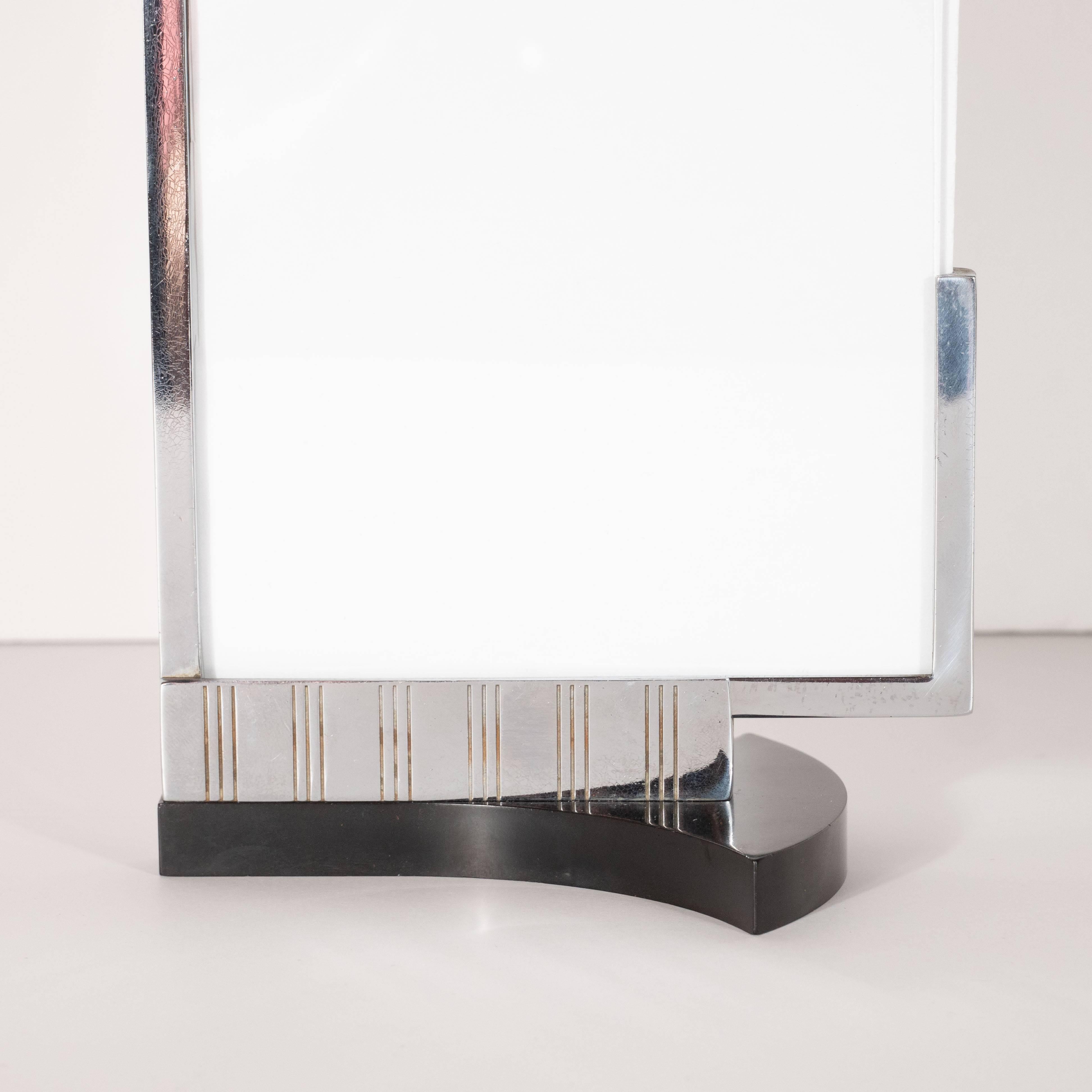 This refined Art Deco Machine age picture frame was realized by Dura Frame Company in the United States, circa 1935. It features a onyx hued bakelite base with streamlined sides that suggests a stylized fan when viewed in profile. The bottom of the