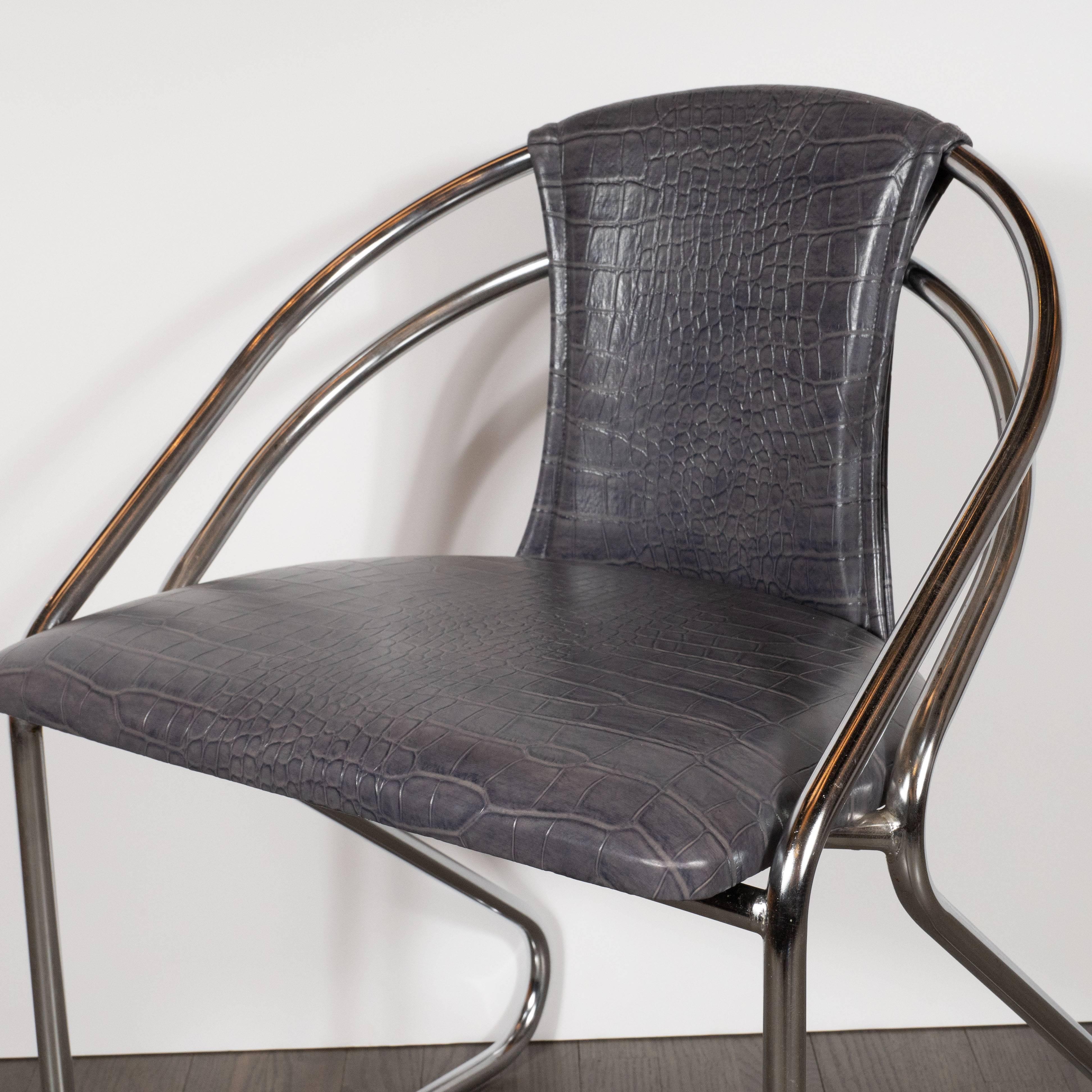 This stunning chair was realized in the United States, circa 1935. The body is composed of bent tubular chrome supports. The base is a triangular form with curved corners that ascends upwards, bending at the seat to form the two barrel back slats.