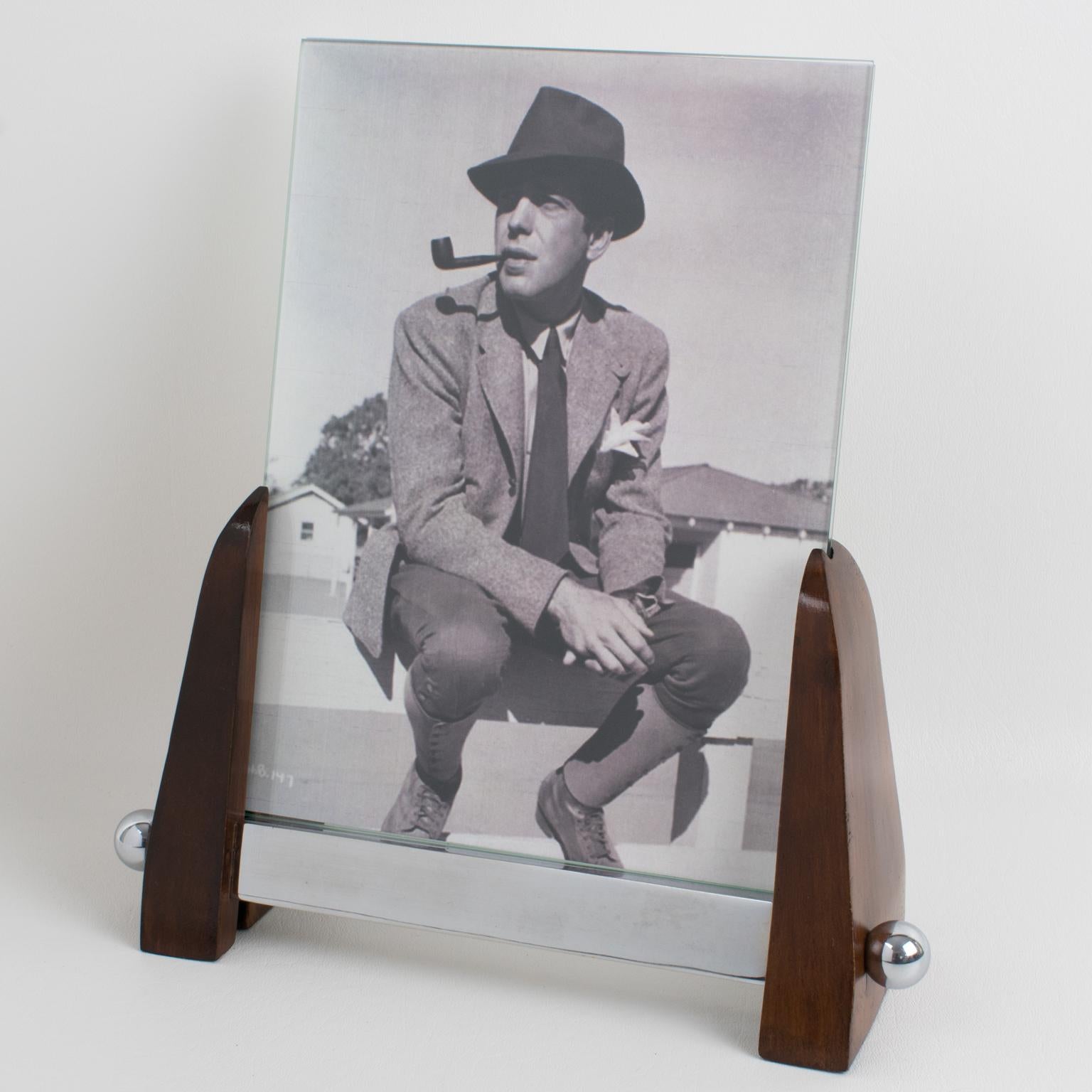 This elegant French Art Deco picture frame features a modernist Machine Age design. Its wood base is ornate with polished chrome accent bar sticks and beads. The photo frame is complete with two glass sheets to enclose the photograph. There is no