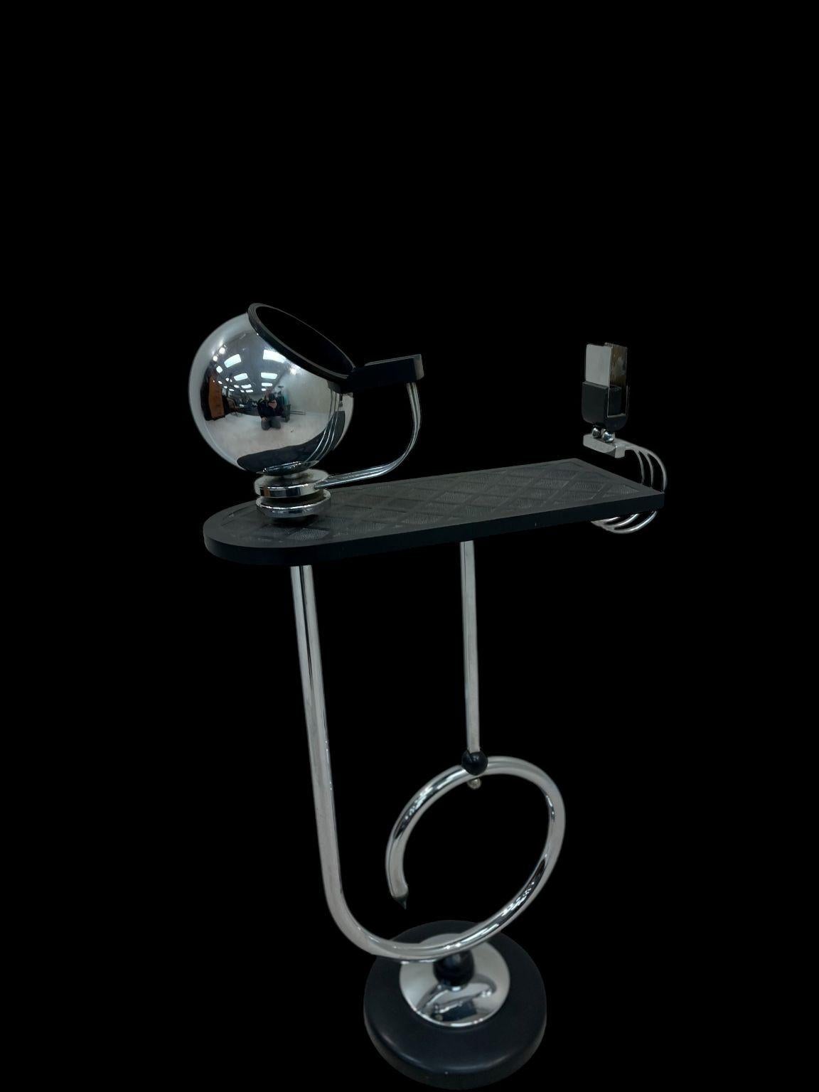 Cendrier unique en chrome et bakélite de style Art Déco. Un design exceptionnellement cool avec un espace réservé aux cigarettes et un cendrier circulaire pivotant.  Etat d'origine. Une petite réparation a été effectuée sur le bord supérieur du