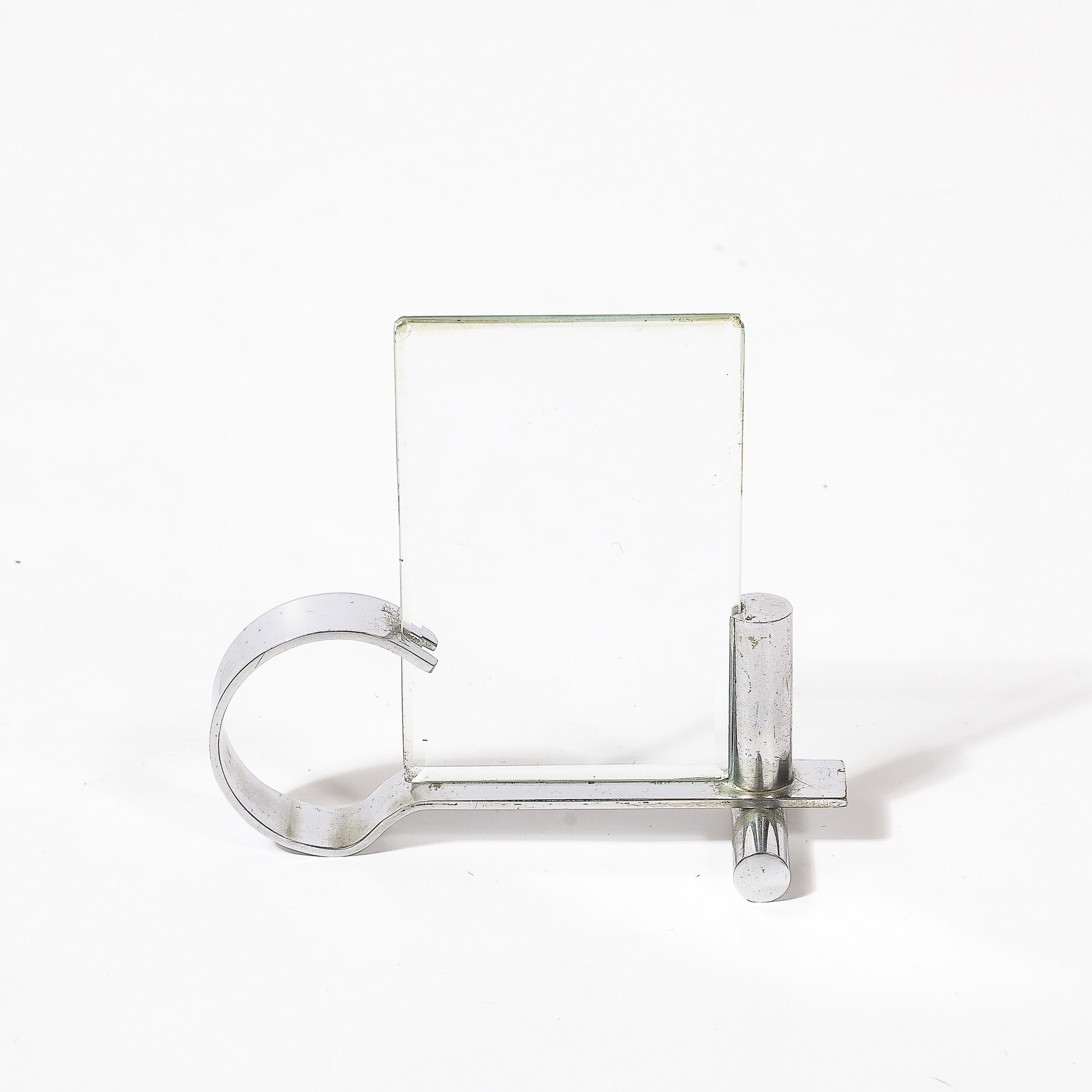 A fine example of Machine Age sophistication, this Art Deco picture frame from circa 1935 embodies the sleek, industrial design ethos of the period. Crafted in gleaming chrome with glass panels, the frame exudes a bold, modernist aesthetic,