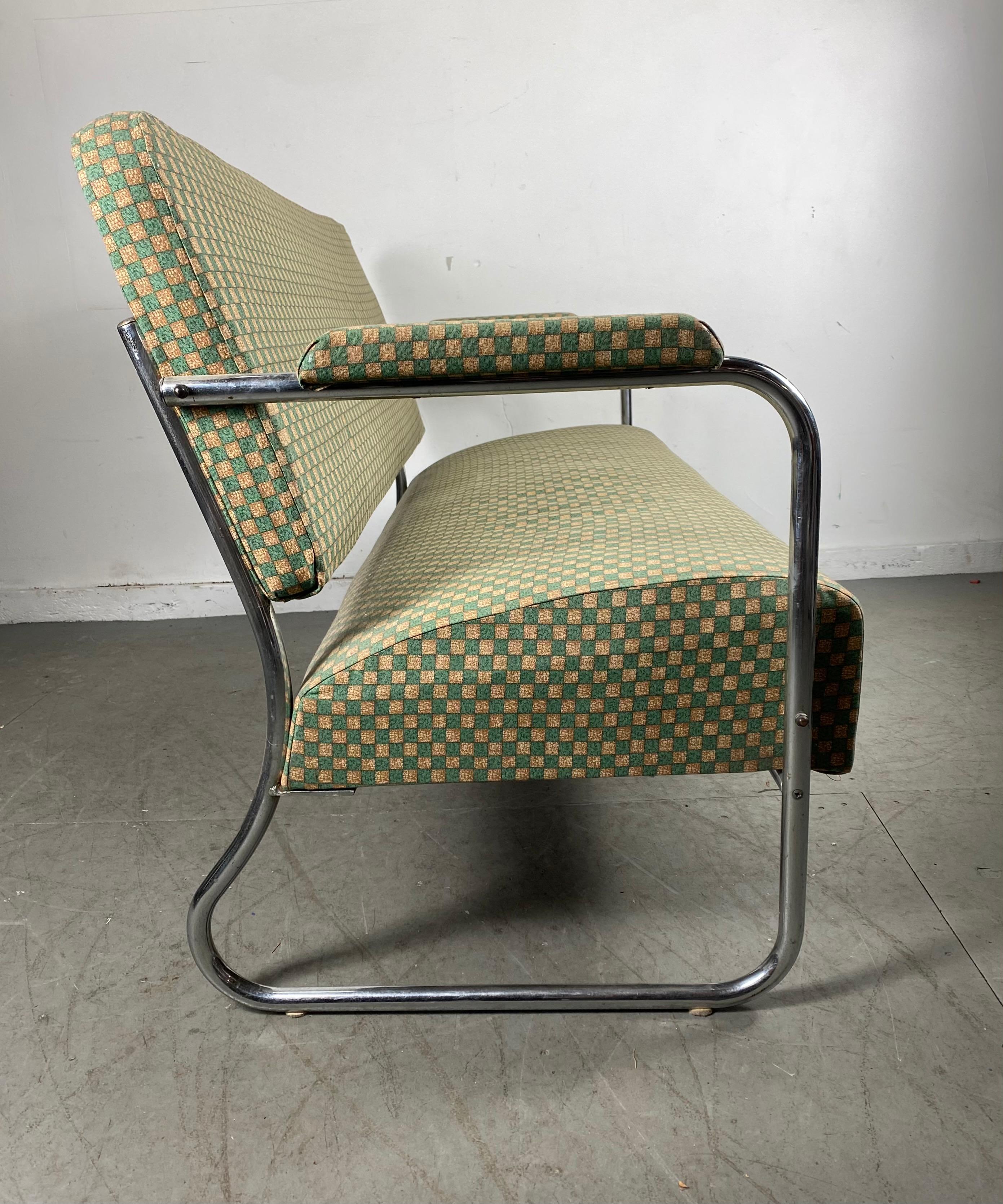 Seldom seen tubular chrome settee / sofa designed by Gilbert Rohde manufactured by Troy Sunshade, model 5556. Beautiful original condition, reupholstered at some point, probably in the 1970s, interesting checkerboard pattern fabric, retains original