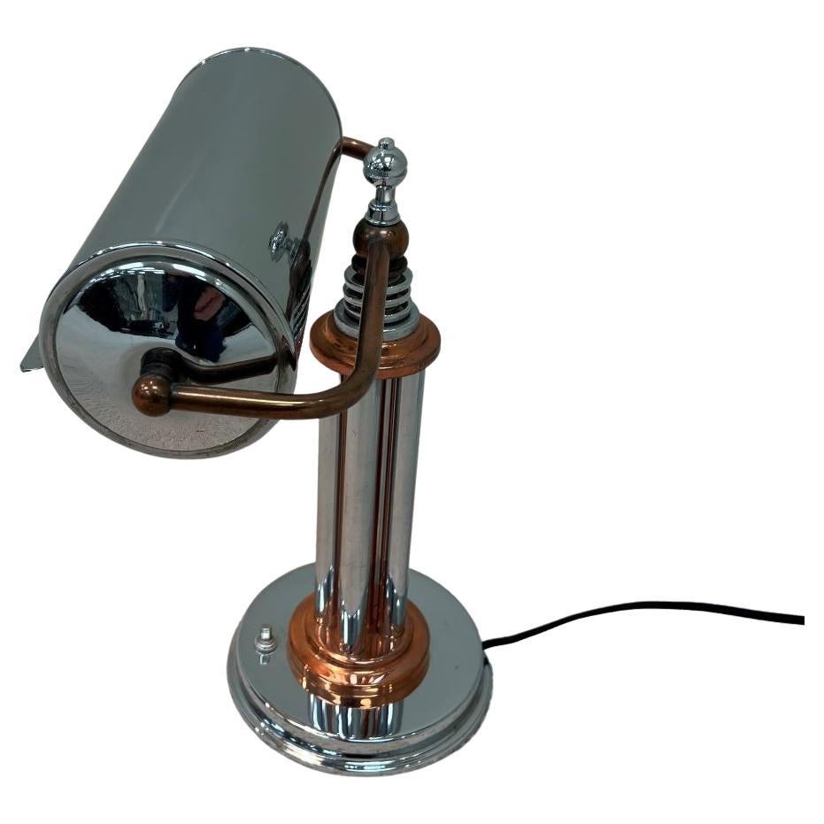 This beautiful Art Deco Machine Age chrome with copper accent lamp is in the style of Markel Lamp Company of Buffalo NY. The unique chrome shade swivels to give more light if necessary. Dimensions 11 inches wide by 13.25 inches high by 8 inches deep.