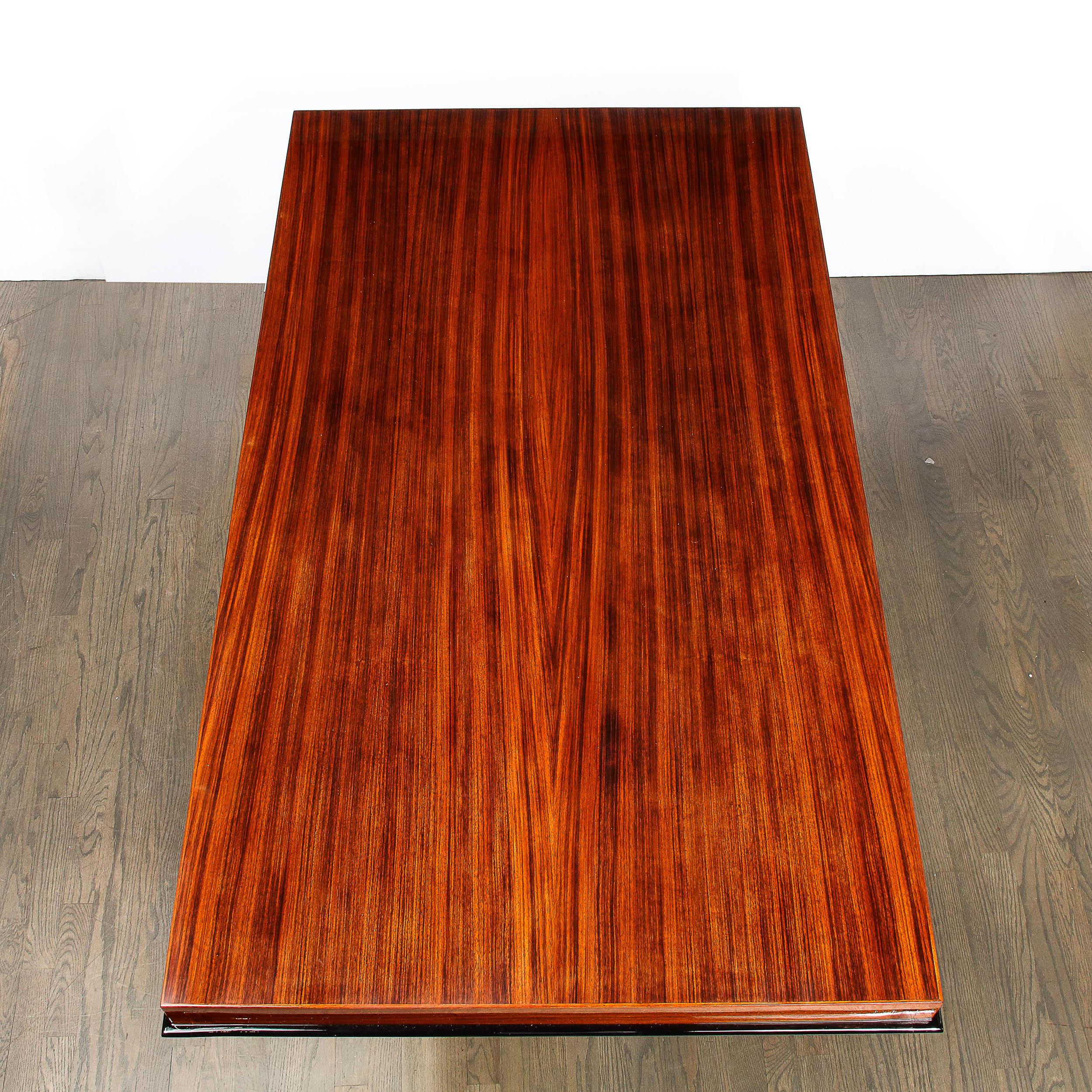 This stunning Art Deco Machine Age cubist dining table was realized in France circa 1935. It features a two tier rectangular skyscraper style base consisting of a rosewood bottom (with a black lacquer top) with another rectangular form (of a smaller