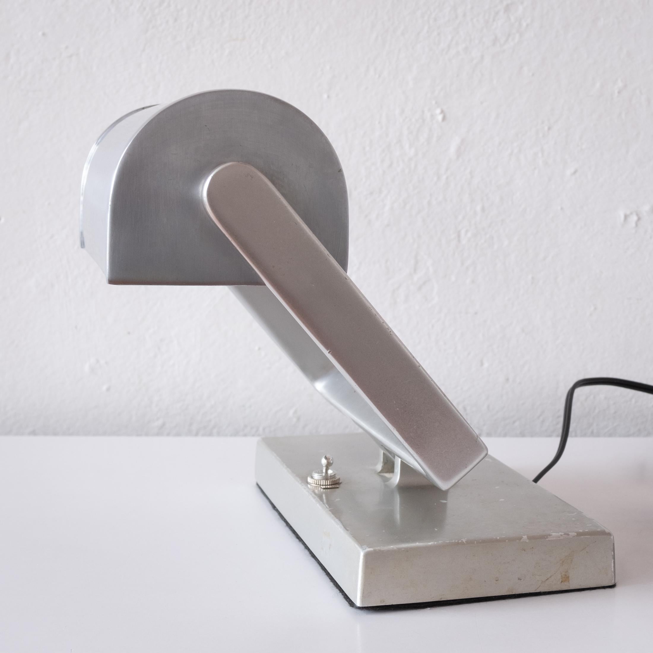 Space age adjustable brushed metal desk or wall lamp. Substantial quality and weight. Fully articulating arm and shade. Includes hanging holes on the bottom to be used as a wall lamp. Professionally rewired. 