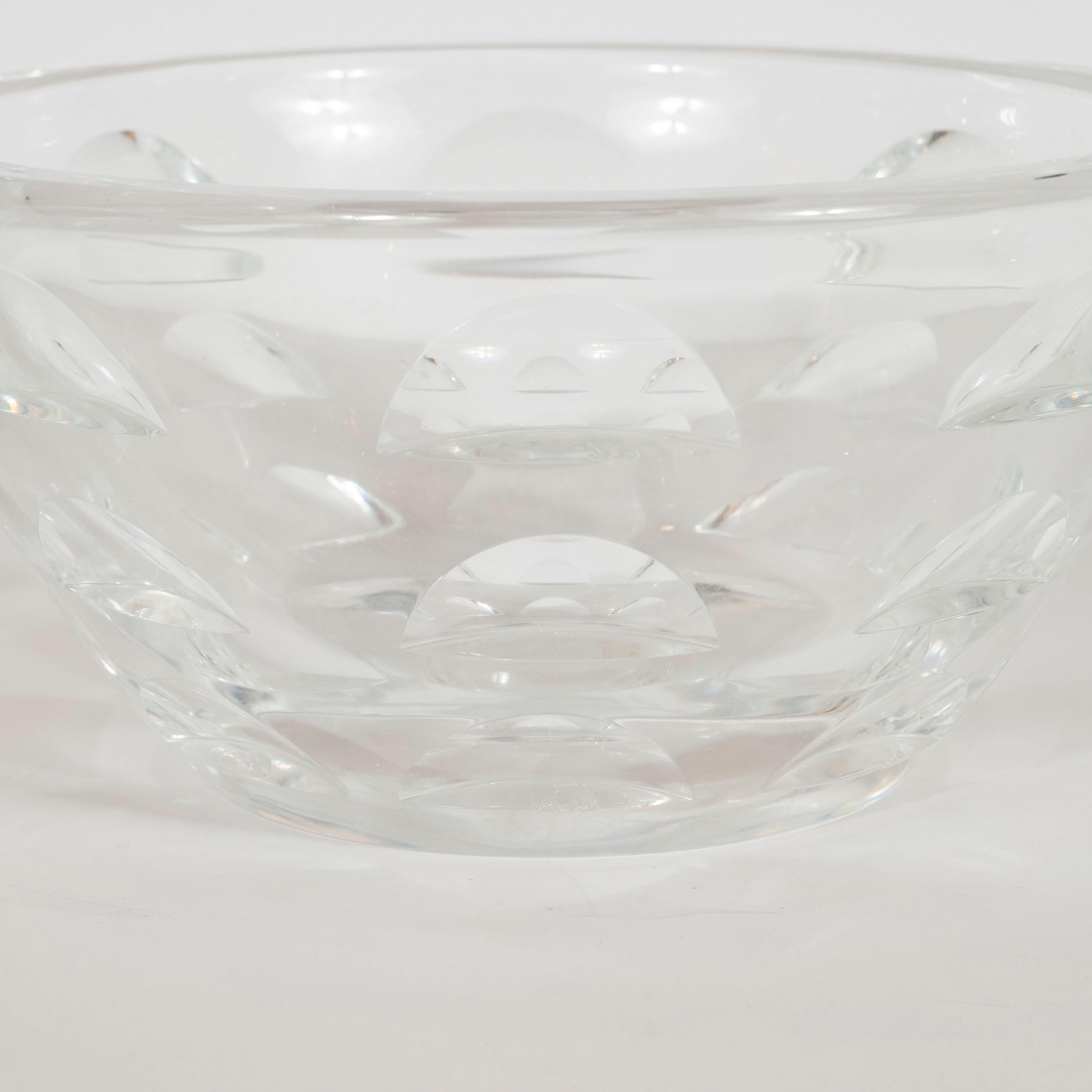 This refined and elegant Art Deco Machine Age bowl was realized by the celebrated American maker, Steuben, circa 1930. It features a conical form in translucent glass with a wealth of incised streamlined forms- a leitmotif of the period. This piece